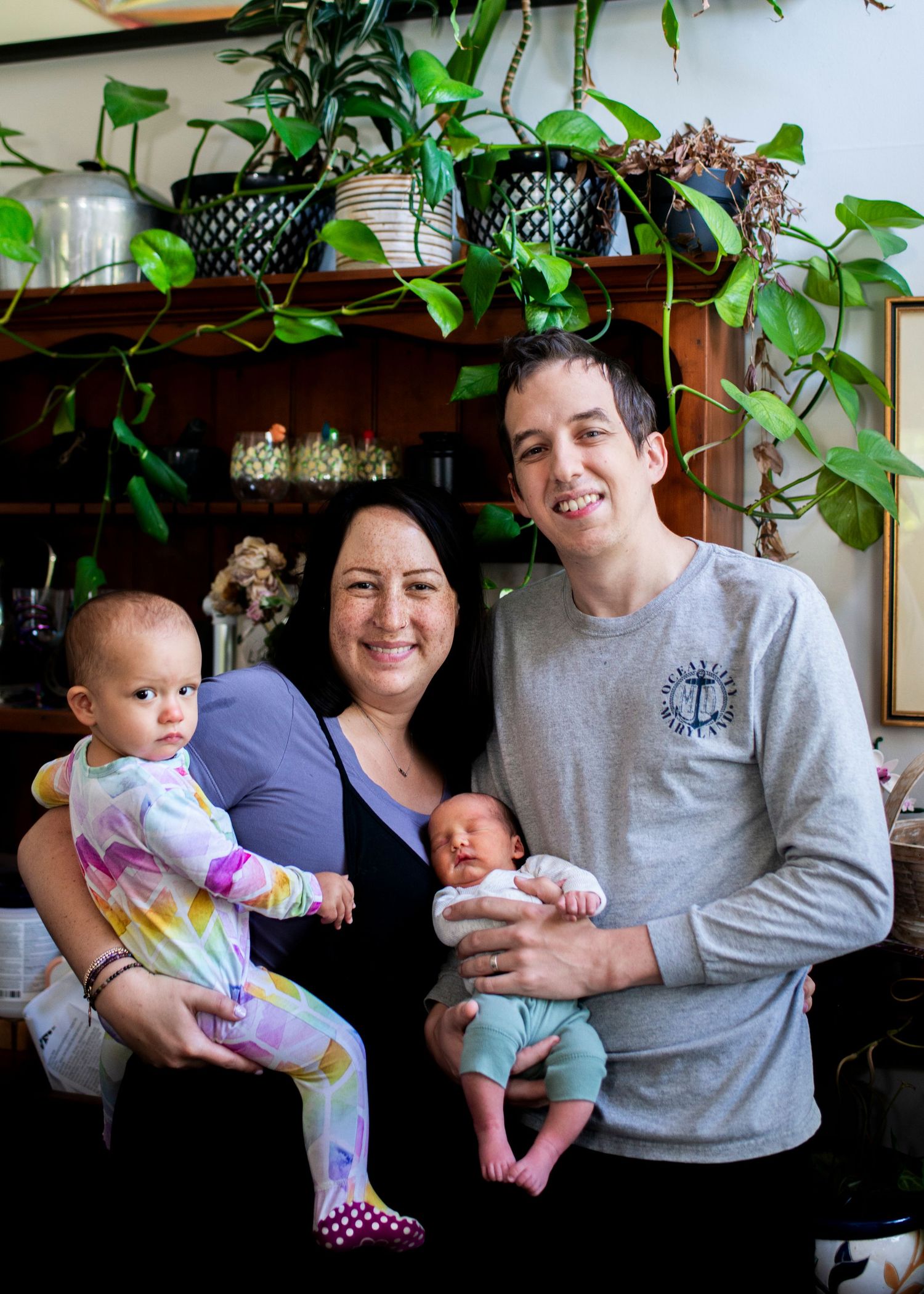 Family with newborn smiles for a portrait in their home.