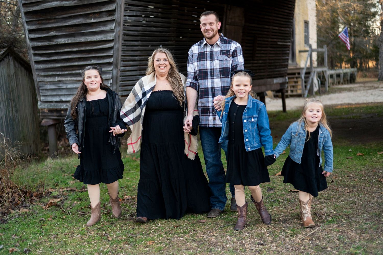 Family of five holds hands, walking and smiling for their portrait at Batsto Historic Village in New Jersey.