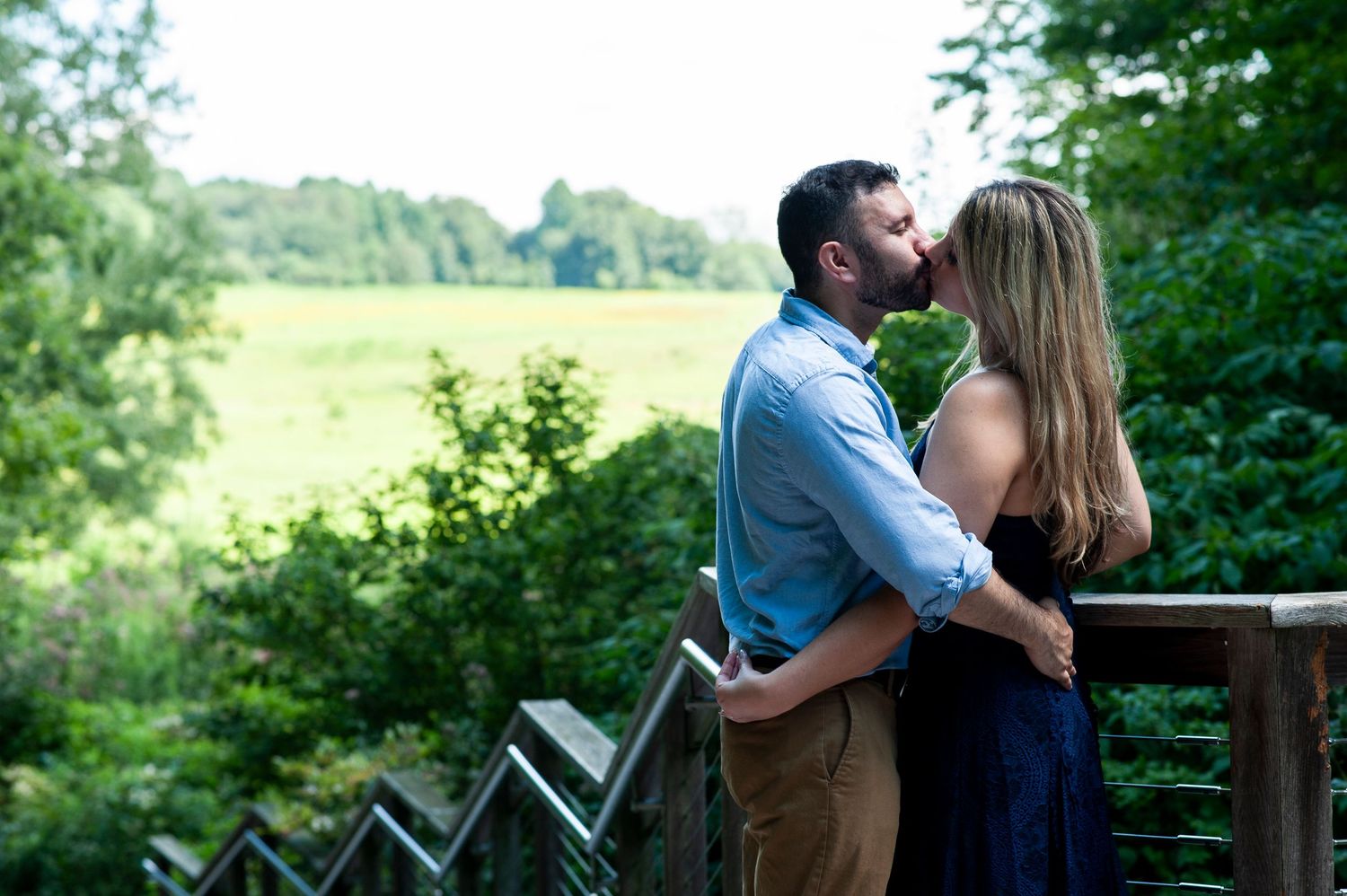 Engaged couple kisses at the top of a staircase at Longwood Gardens in Pennsylvania.