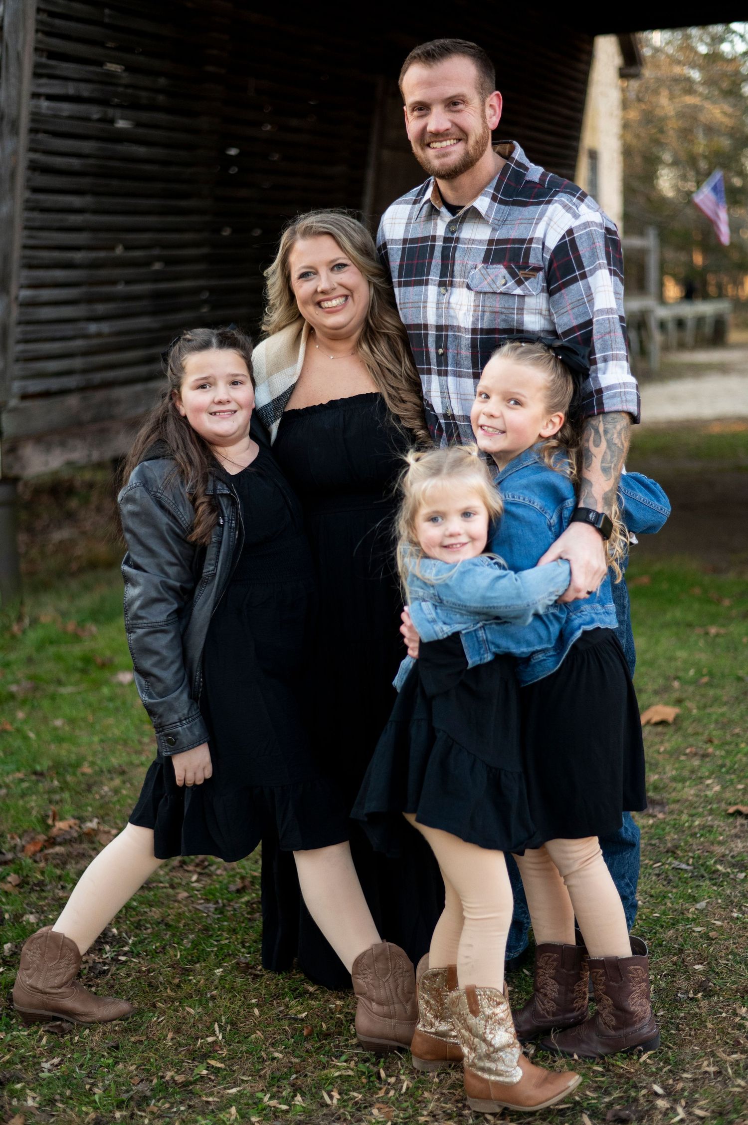 Family of five hugs and looks at the camera in Batsto Historic Village in New Jersey.