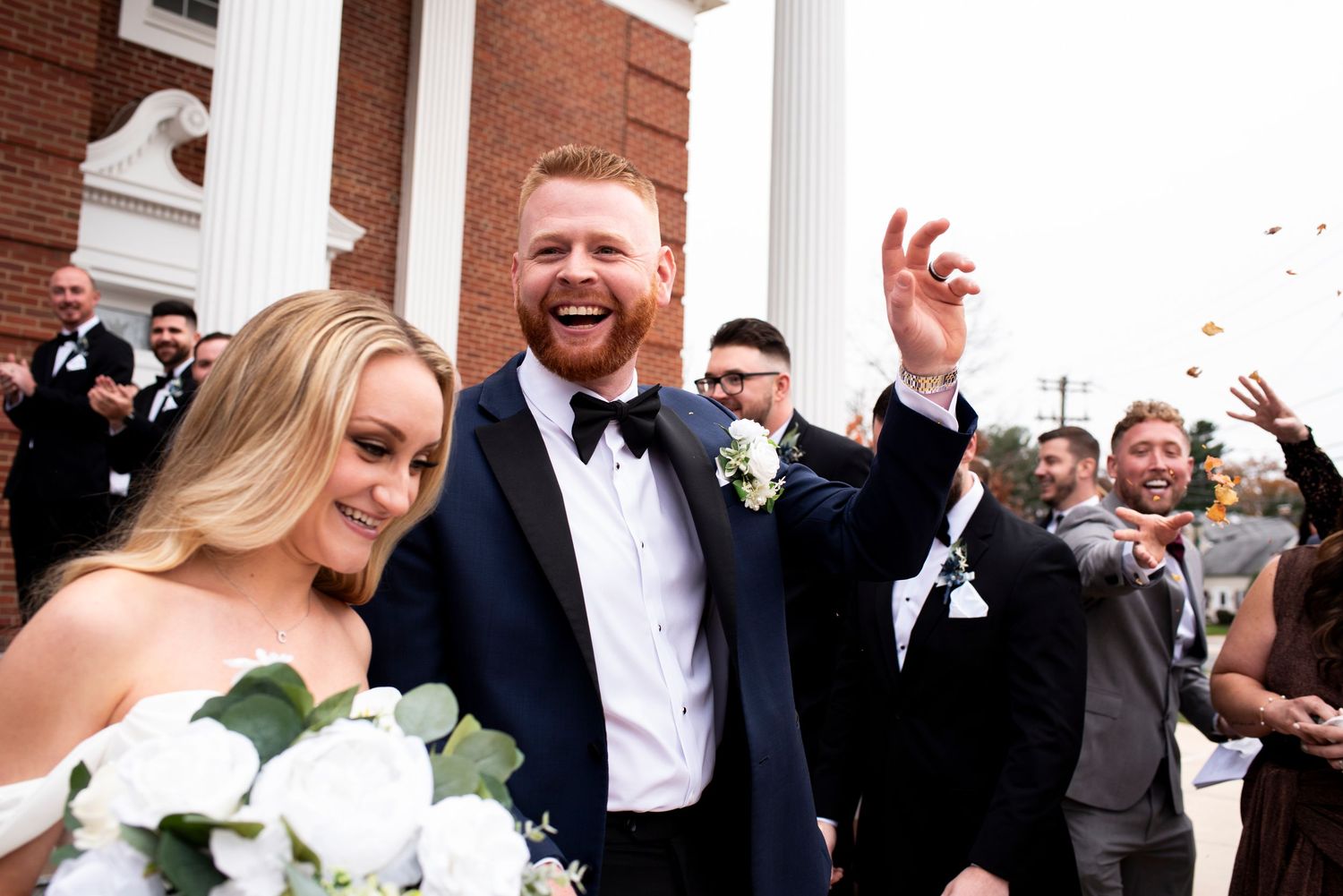 Bride and groom smile during wedding ceremony recessional outside of church in Pennsylvania.