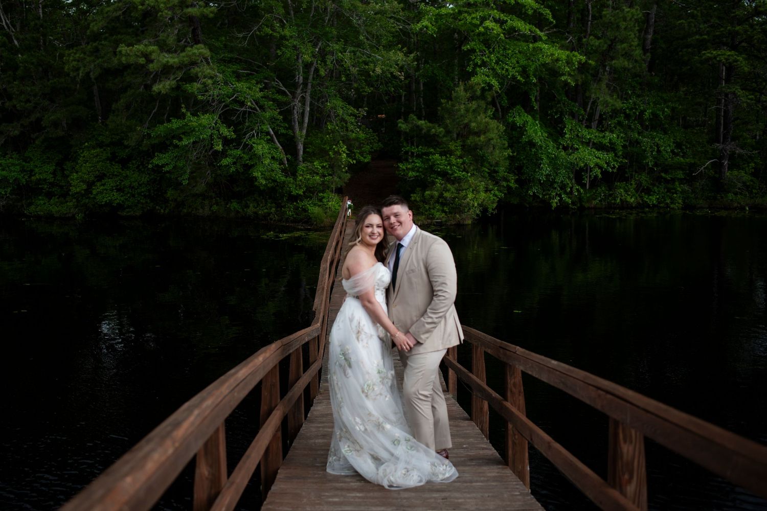 Bride and groom smile, heads together, on Senior Bridge after their wedding ceremony at Camp Matollionequay in Medford, New Jersey.