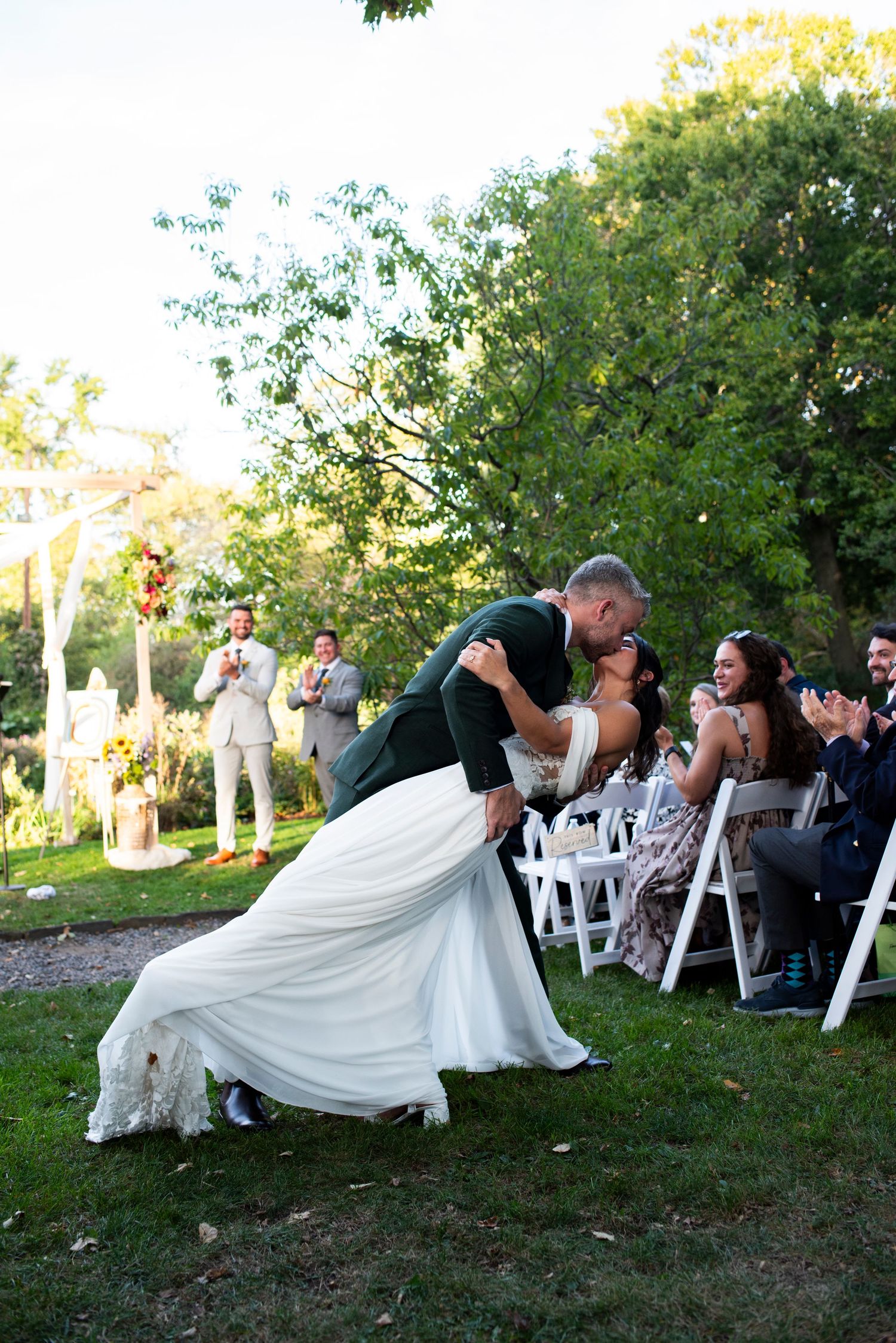 Bride and groom dip for a kiss in the aisle after during their ceremony recessional in Bartram's Garden in Philadelphia, PA.