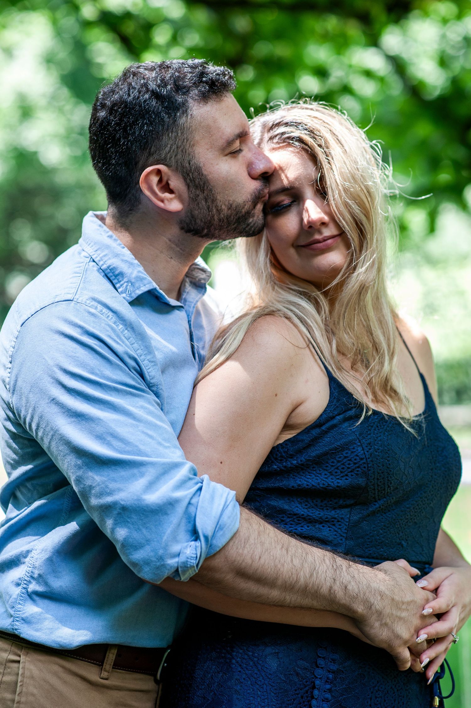 Man kisses his future bride on the temple during engagement shoot at Longwood Gardens in Pennsylvania.