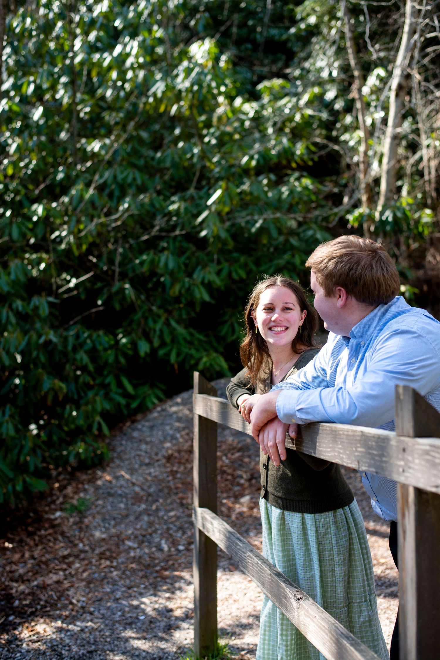 Engaged couple smile at each other on the bridge at Hawk Falls in Pennsylvania.