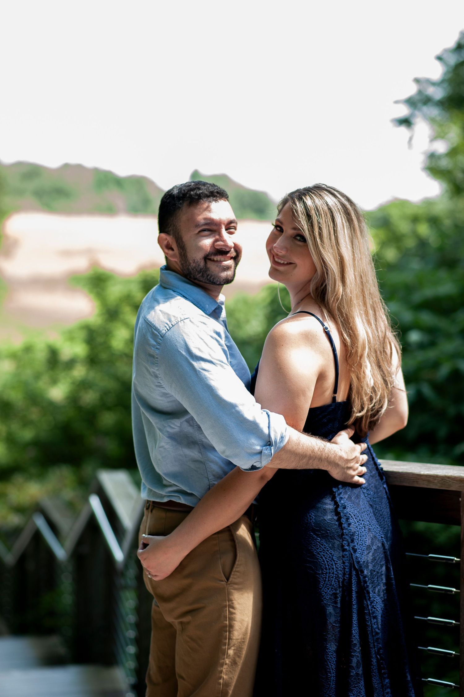 Engaged couple looks back at the camera and smiles at Longwood Gardens in Pennsylvania.
