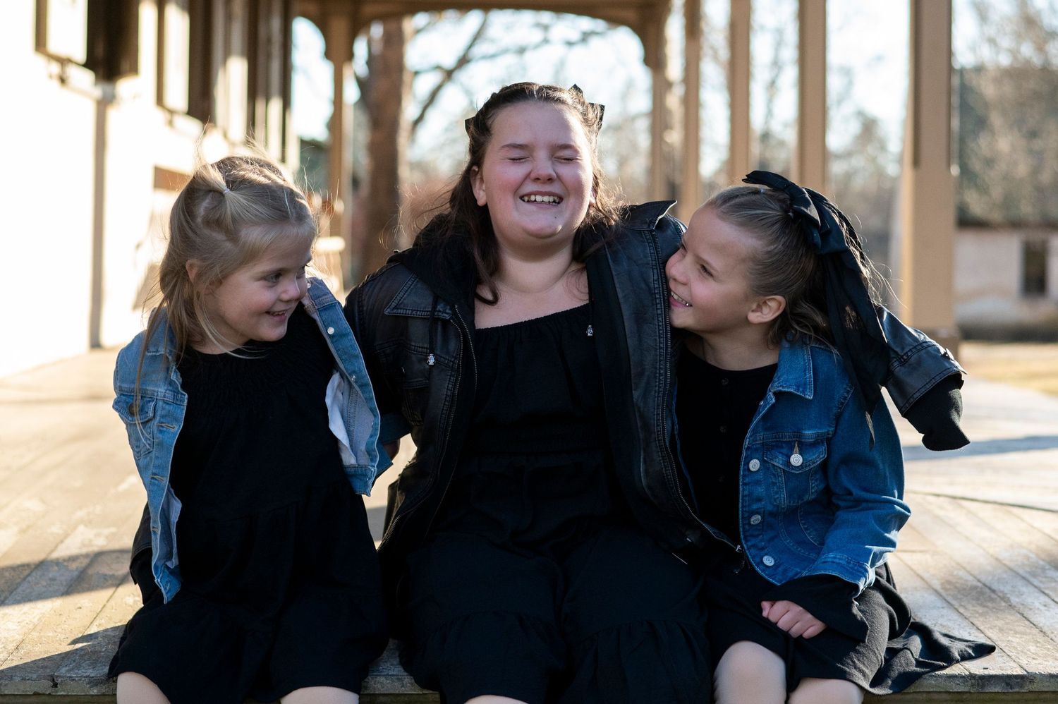 Three sisters laugh together on porch at Batsto Historic Village in New Jersey.