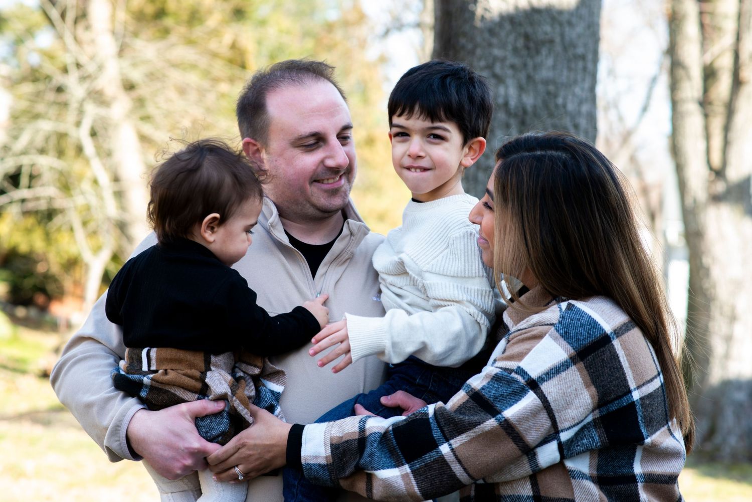 Family of four smile at one another outside of their home in Cherry Hill, NJ.