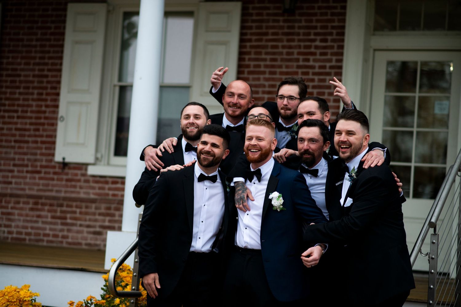 Groomsmen come together for portrait outside at Lazaretto Ballroom in Pennsylvania.