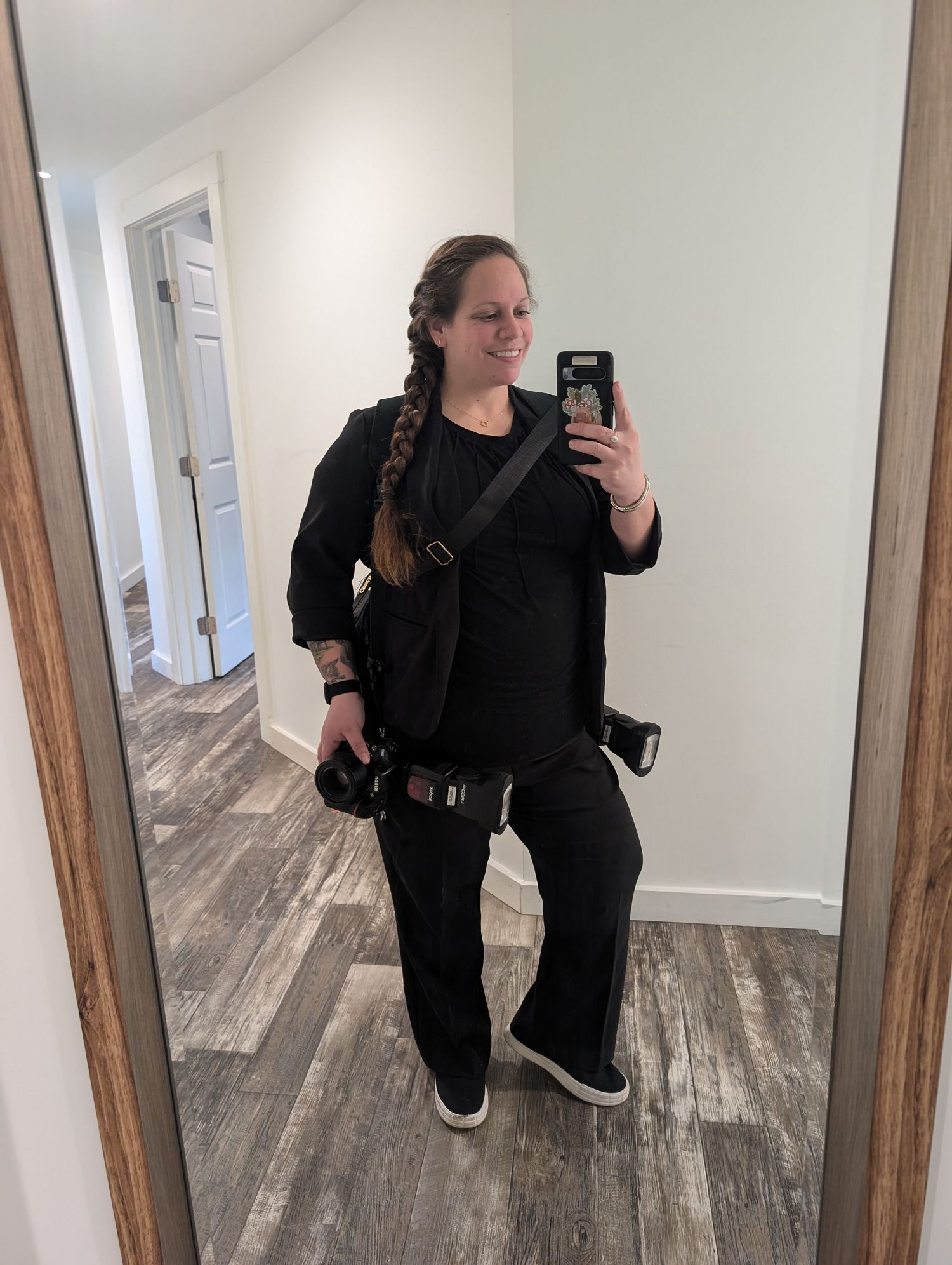 Photographer selfie in mirror with two cameras at her sides.