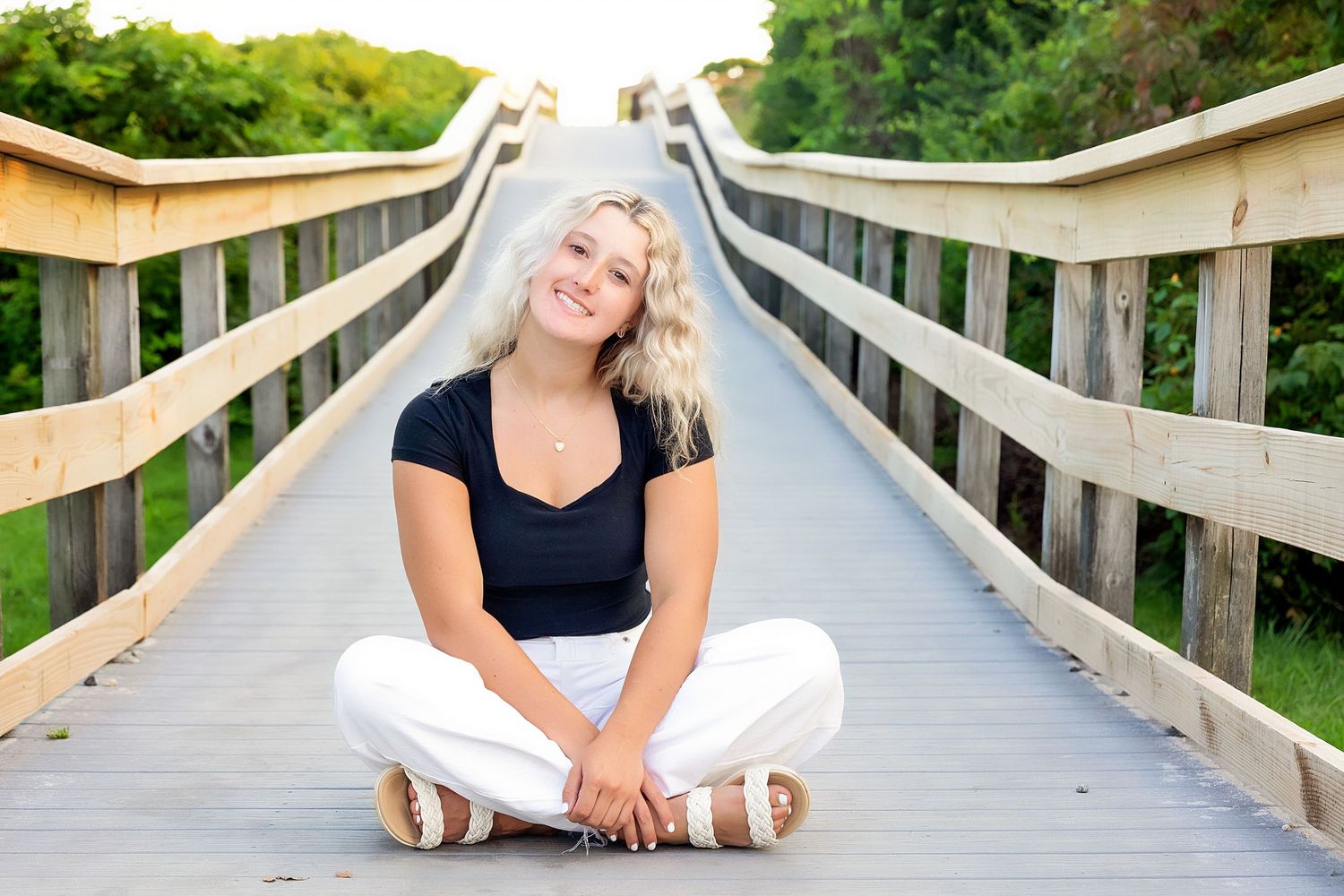 Relaxed poses captured on a wooden boardwalk during golden hour.