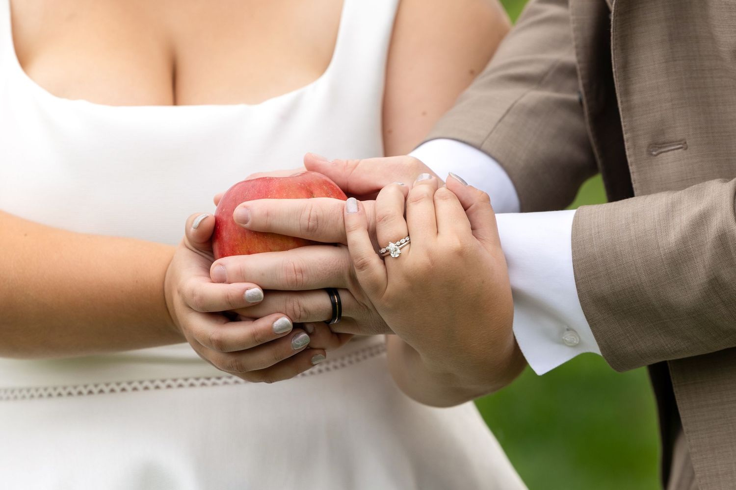 Close-up of hands exchanging wedding rings during ceremony.