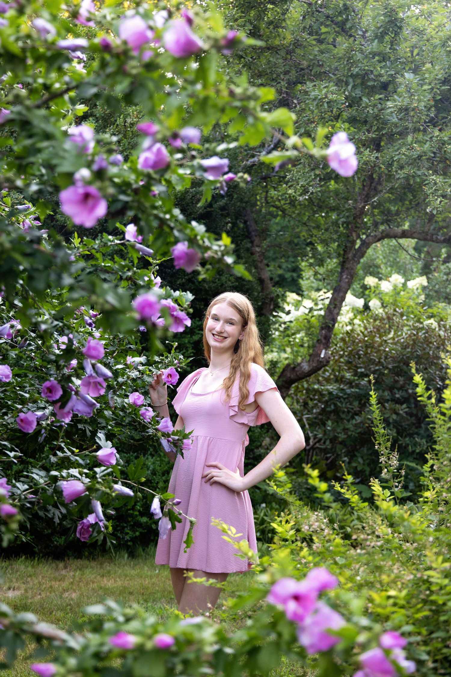 Garden photoshoot with blooming purple flowers creating a dreamy atmosphere.