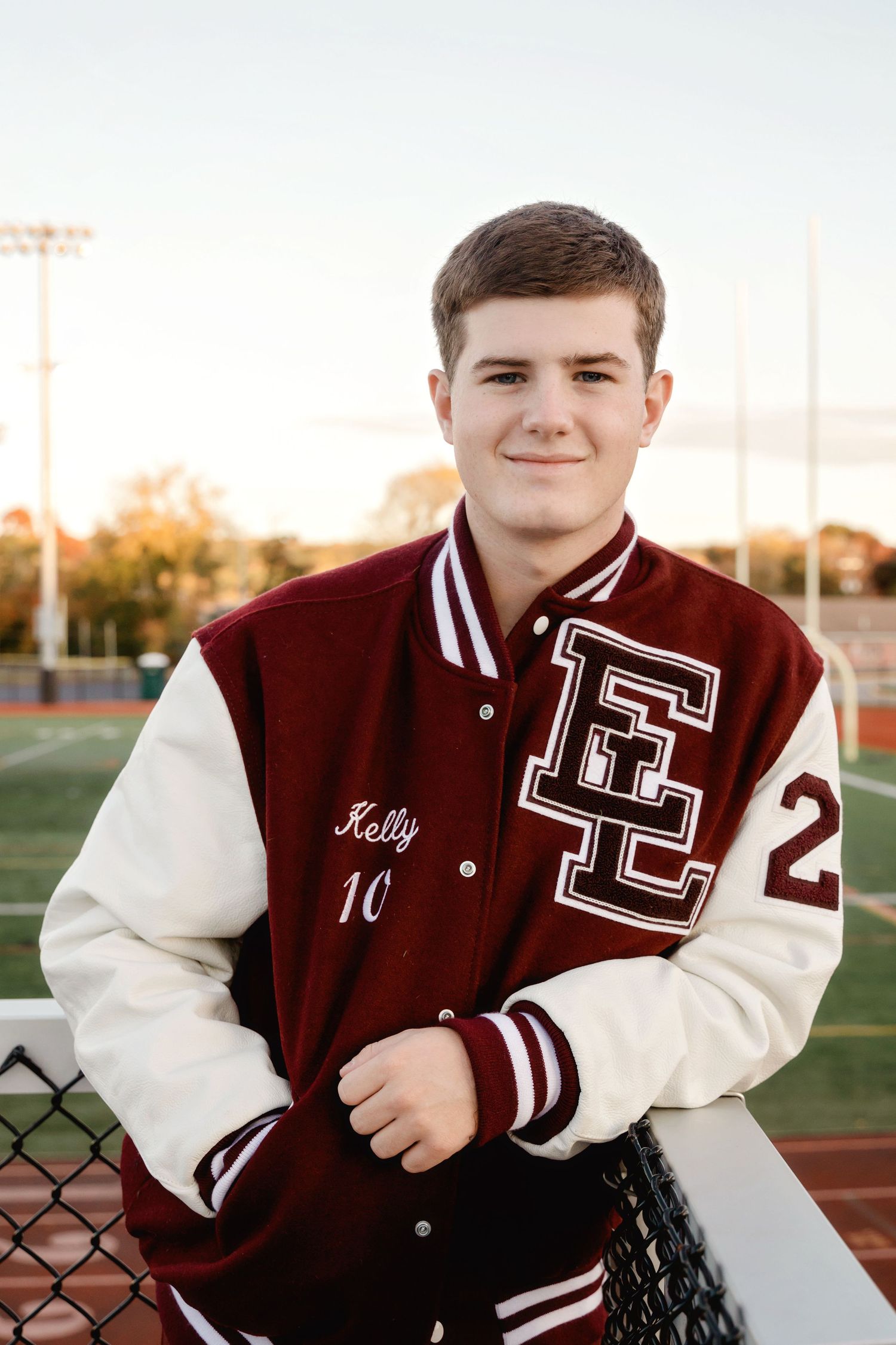 A series of photos showing someone wearing a maroon and white varsity letterman jacket posing outdoors at a sports field.