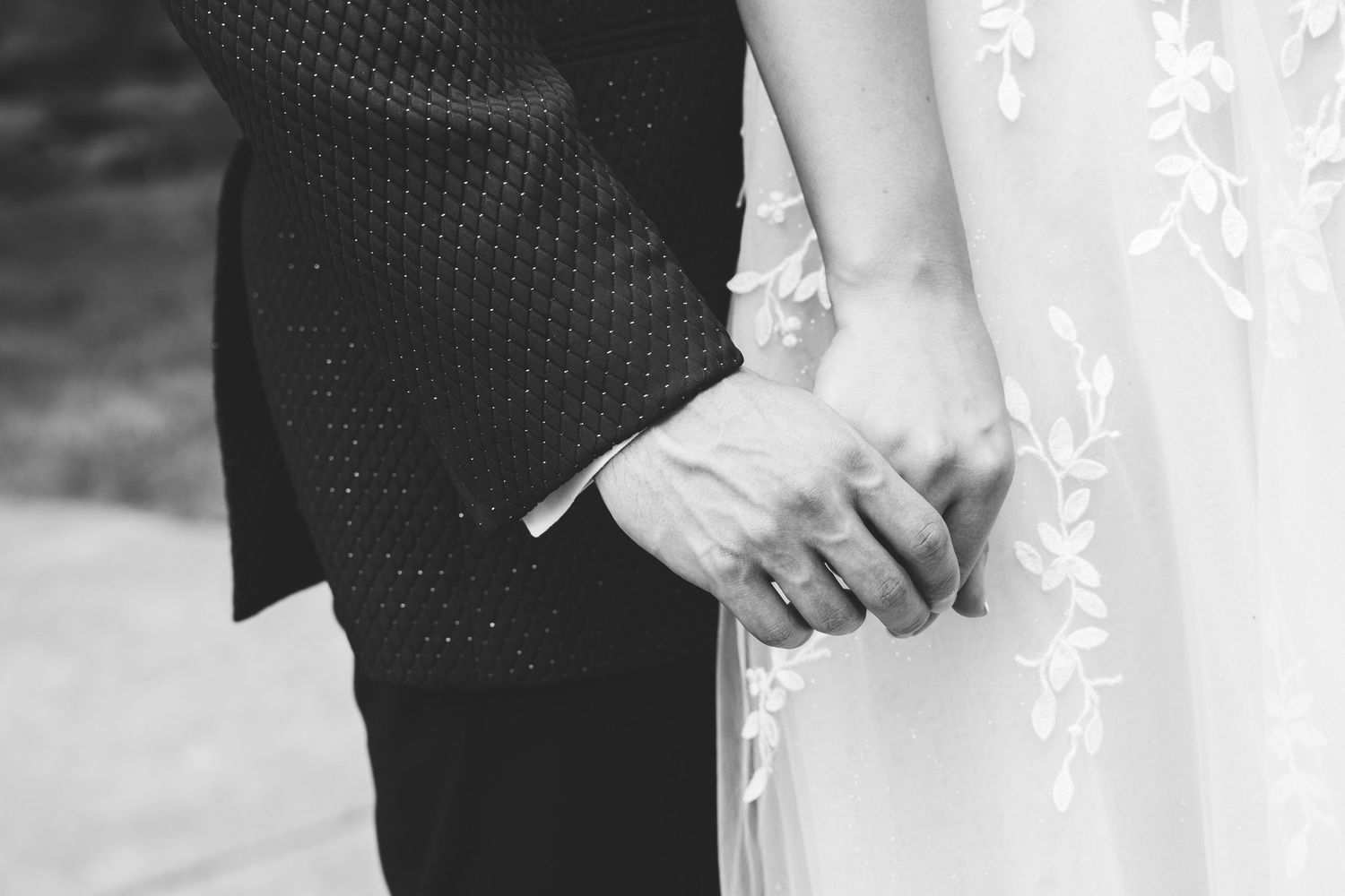 A black and white wedding photo collage showing close-up details of the couple's hands, rings, and formal attire.