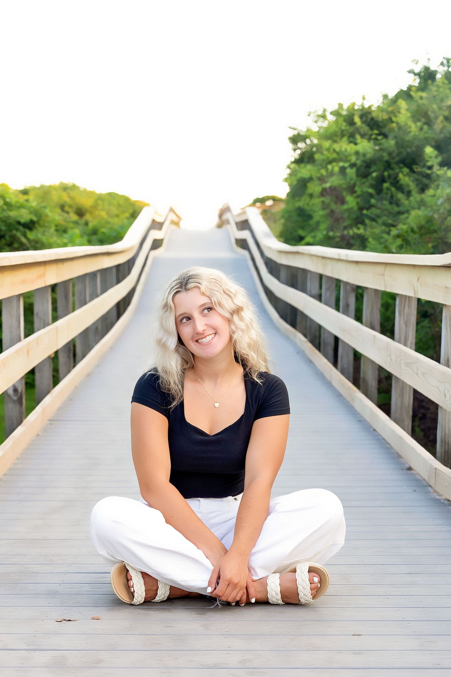 Artistic poses on a wooden boardwalk surrounded by natural scenery.
