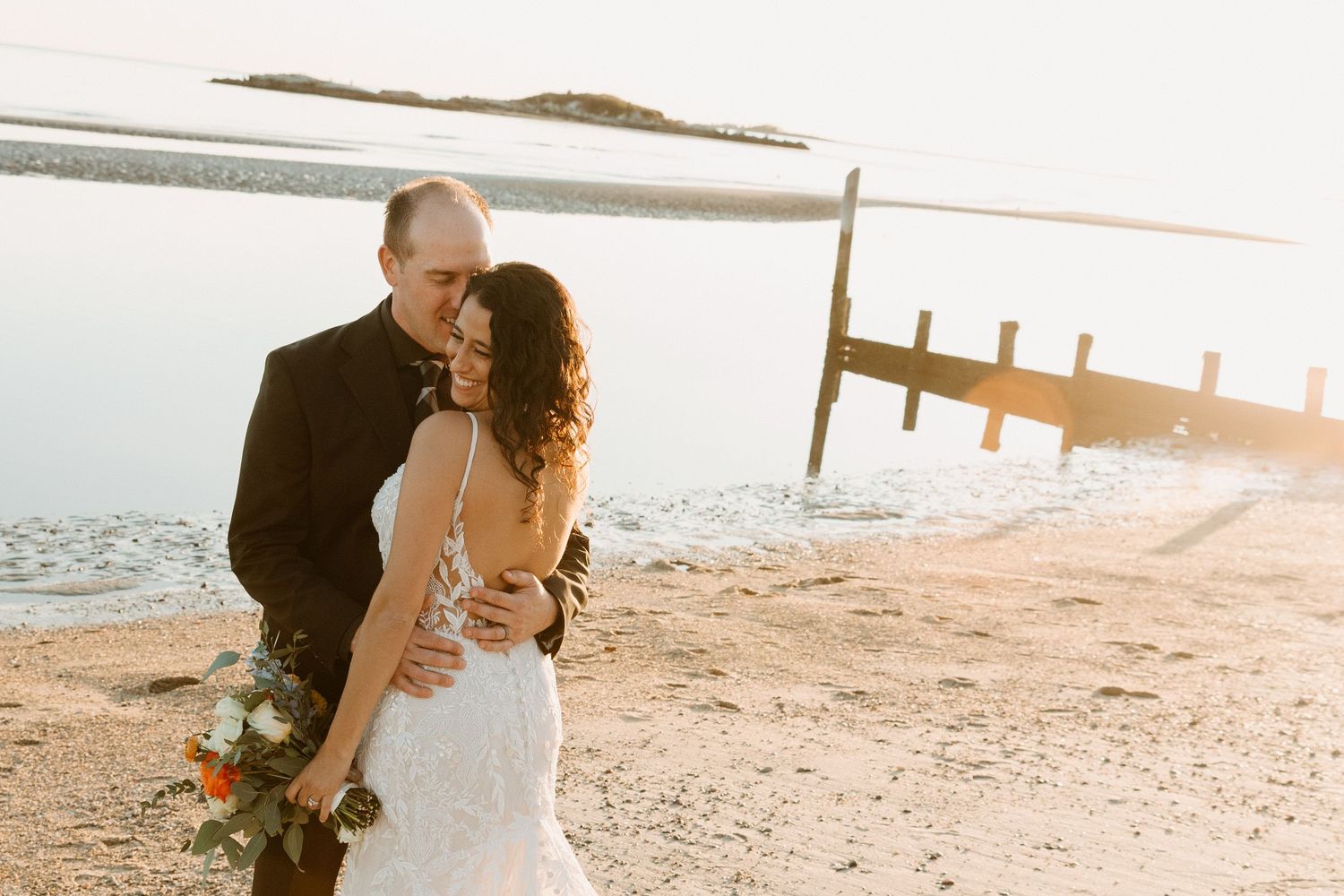Romantic sunset beach portrait with dock in background.
