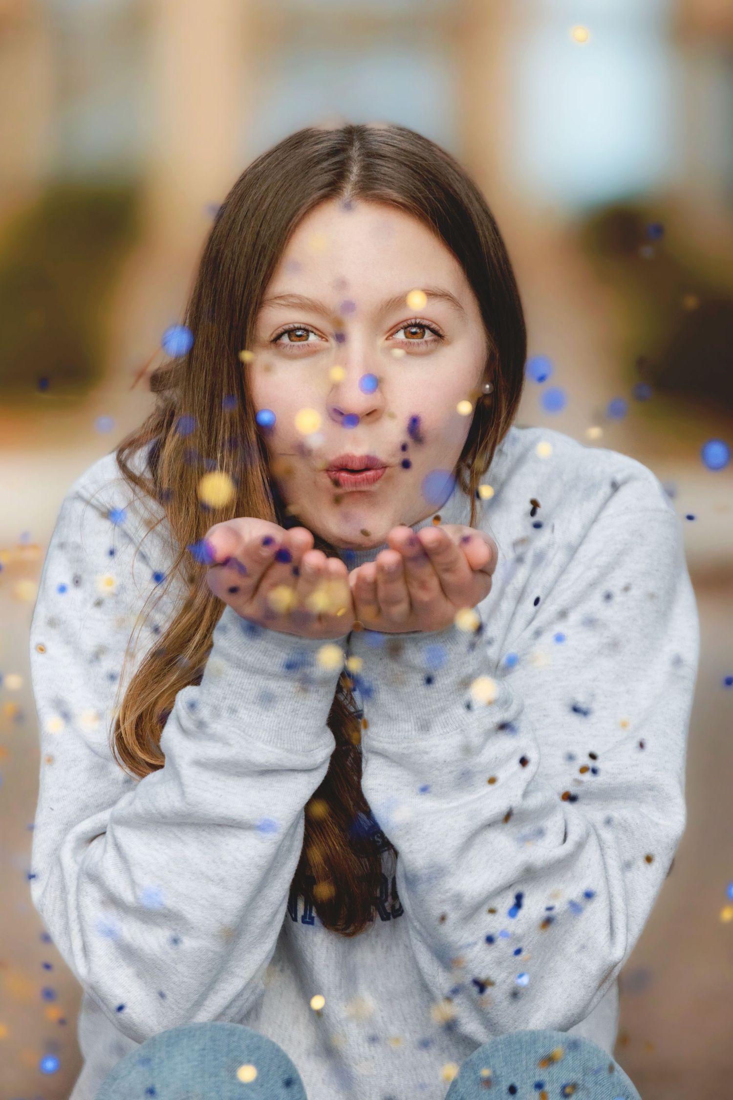 A sequence of photos showing someone blowing blue and silver confetti from their hands in a celebratory moment.