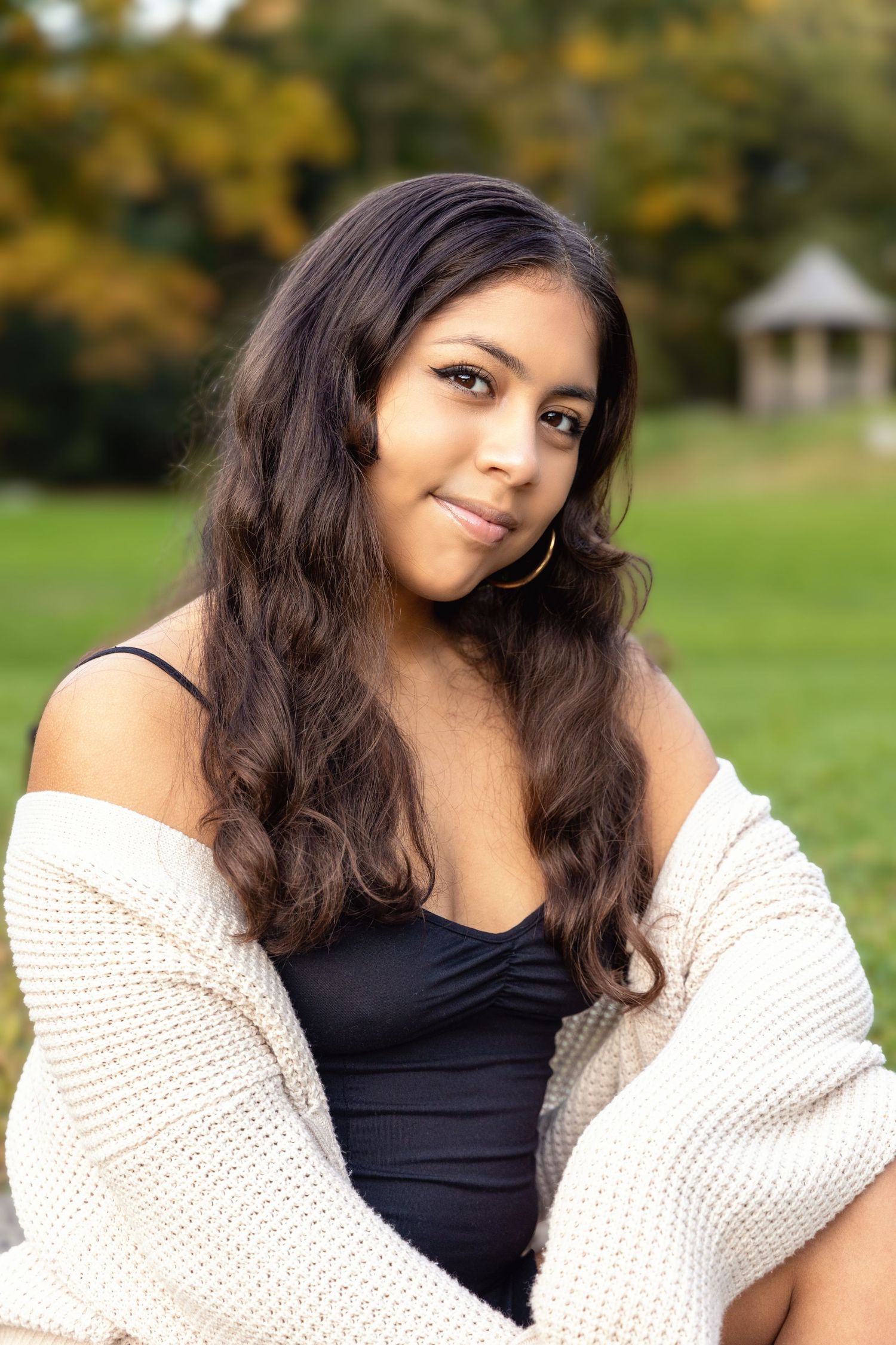 A series of outdoor portrait photos showing someone wearing a black top and cream cardigan in a park setting.