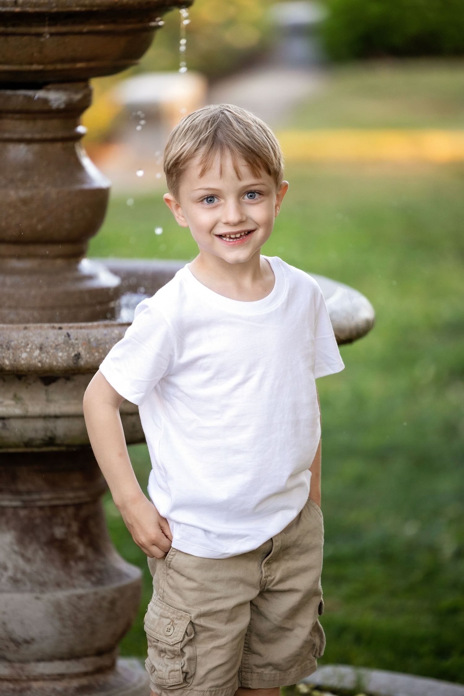A child in a white t-shirt and khaki shorts poses playfully outdoors in a sequence of three photos.