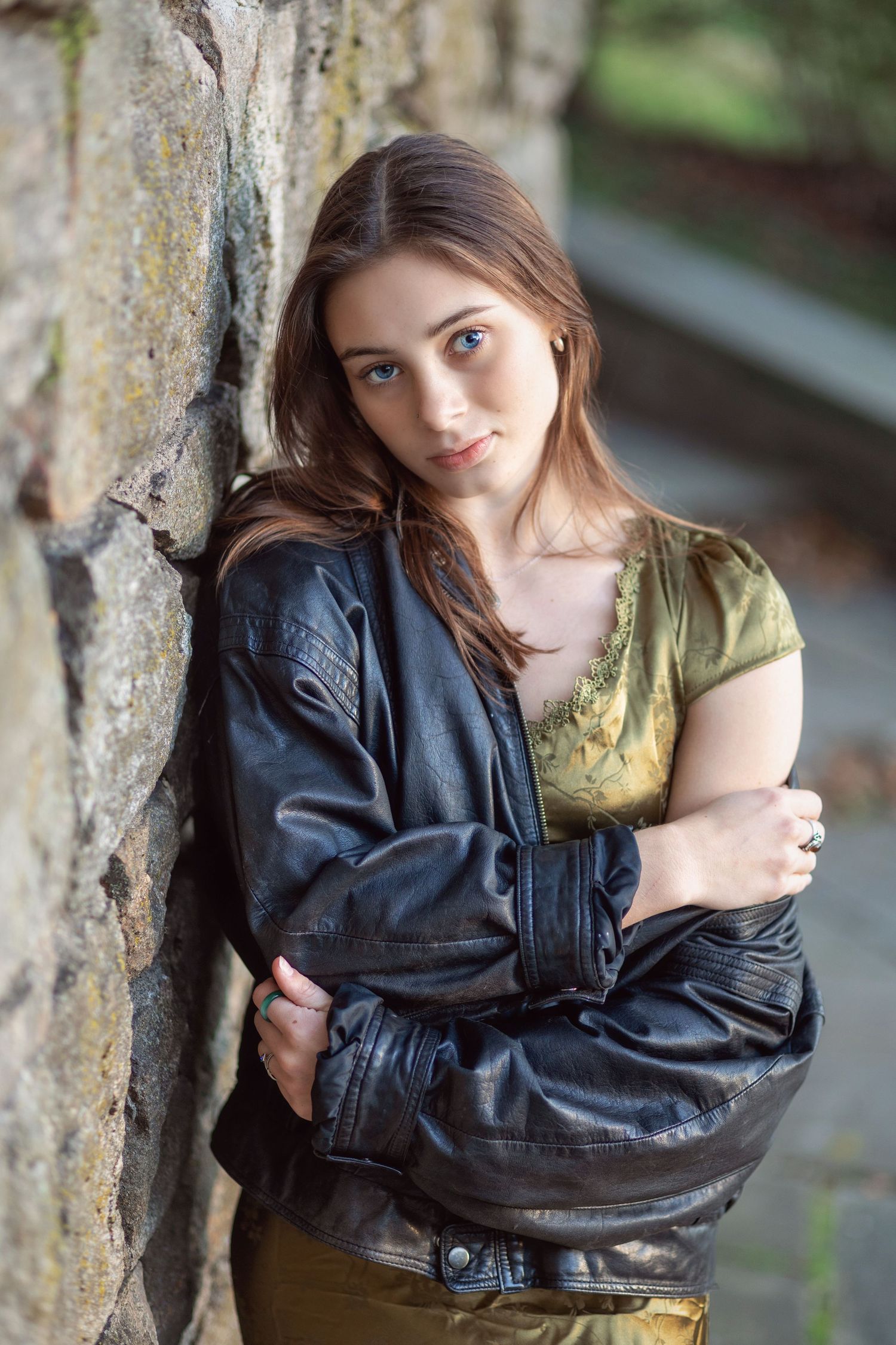 A series of artistic portraits showing someone in a black leather jacket posing against a tree trunk in natural lighting.