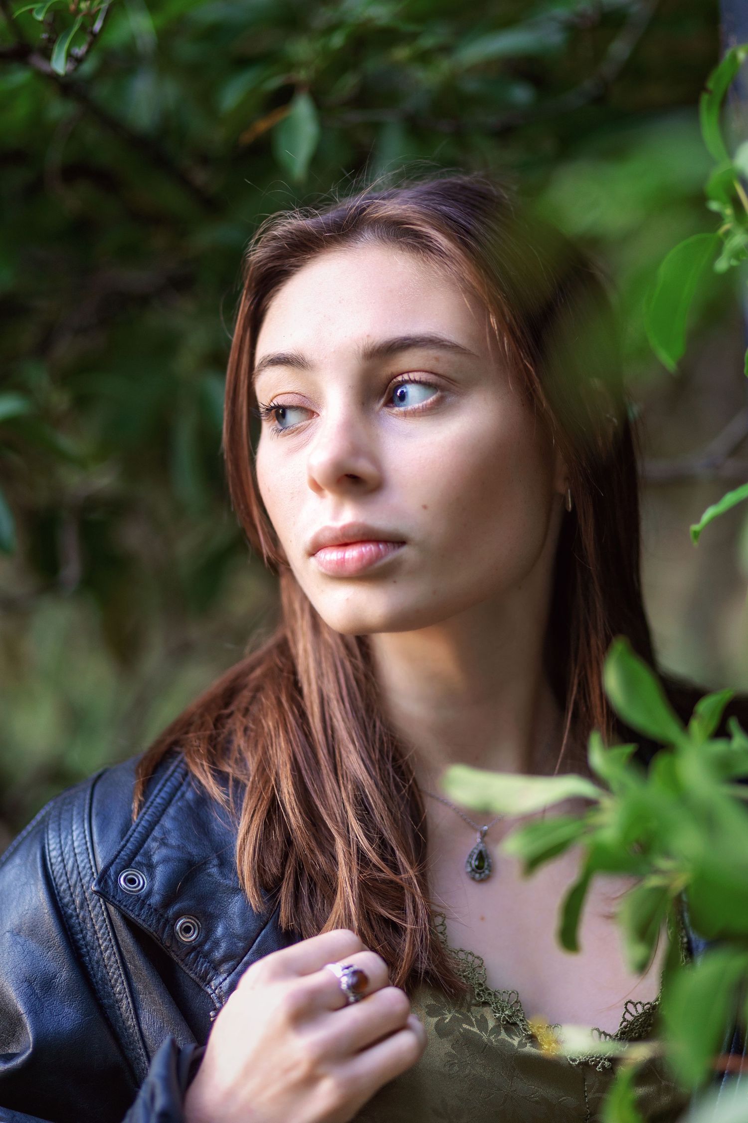 Close-up portrait shots with green foliage in the background, featuring soft natural lighting and gentle expressions.