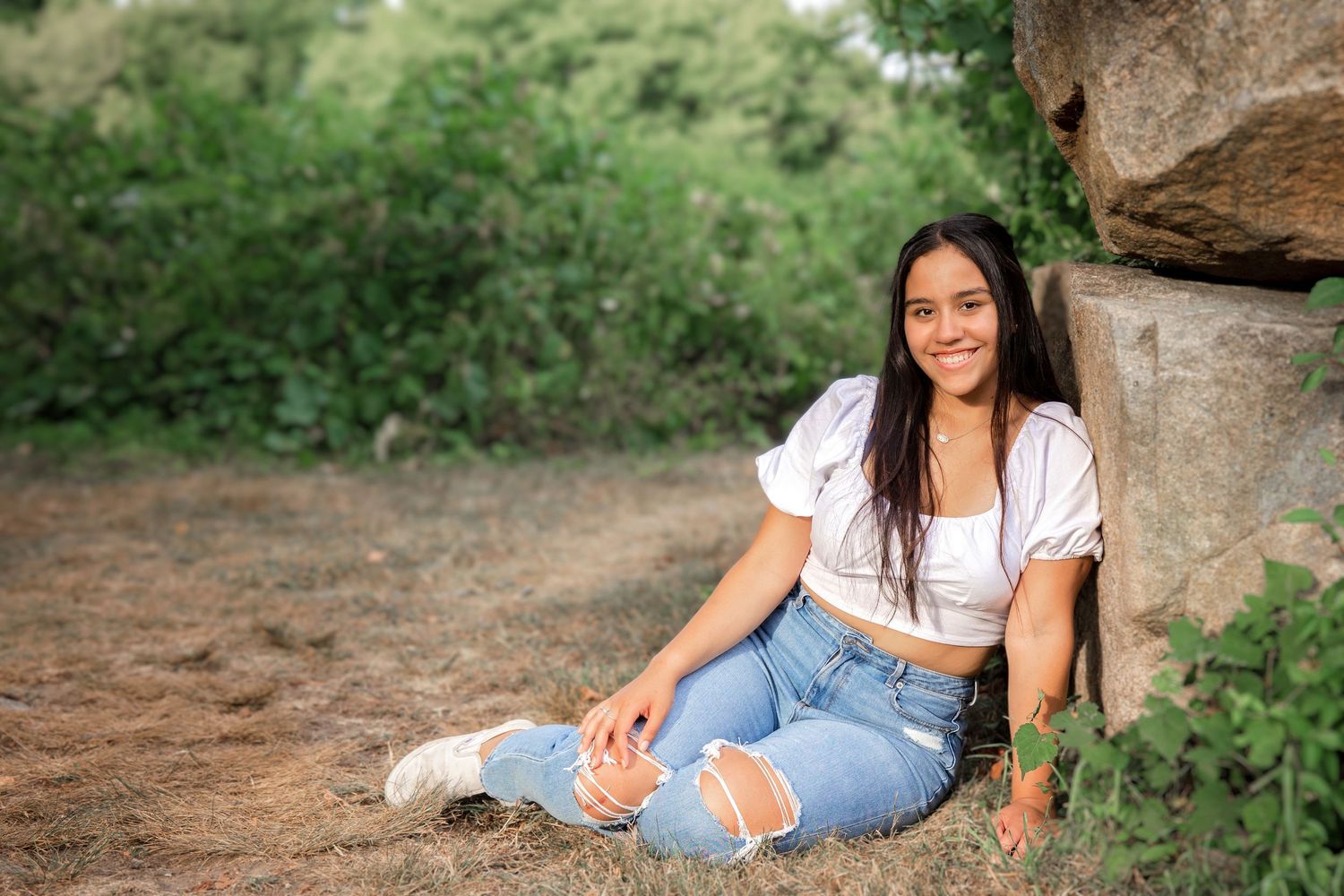A series of outdoor portrait photos showing someone in casual attire posing against natural rock formations and greenery.