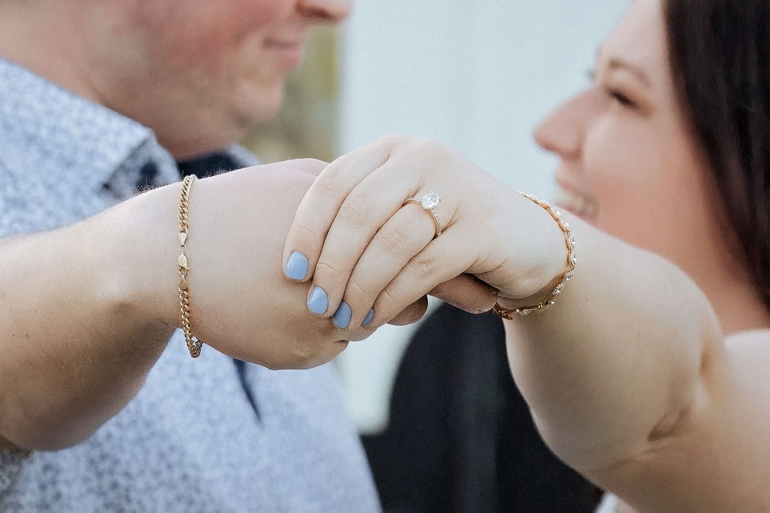 Close up of hands exchanging wedding rings during an outdoor ceremony.