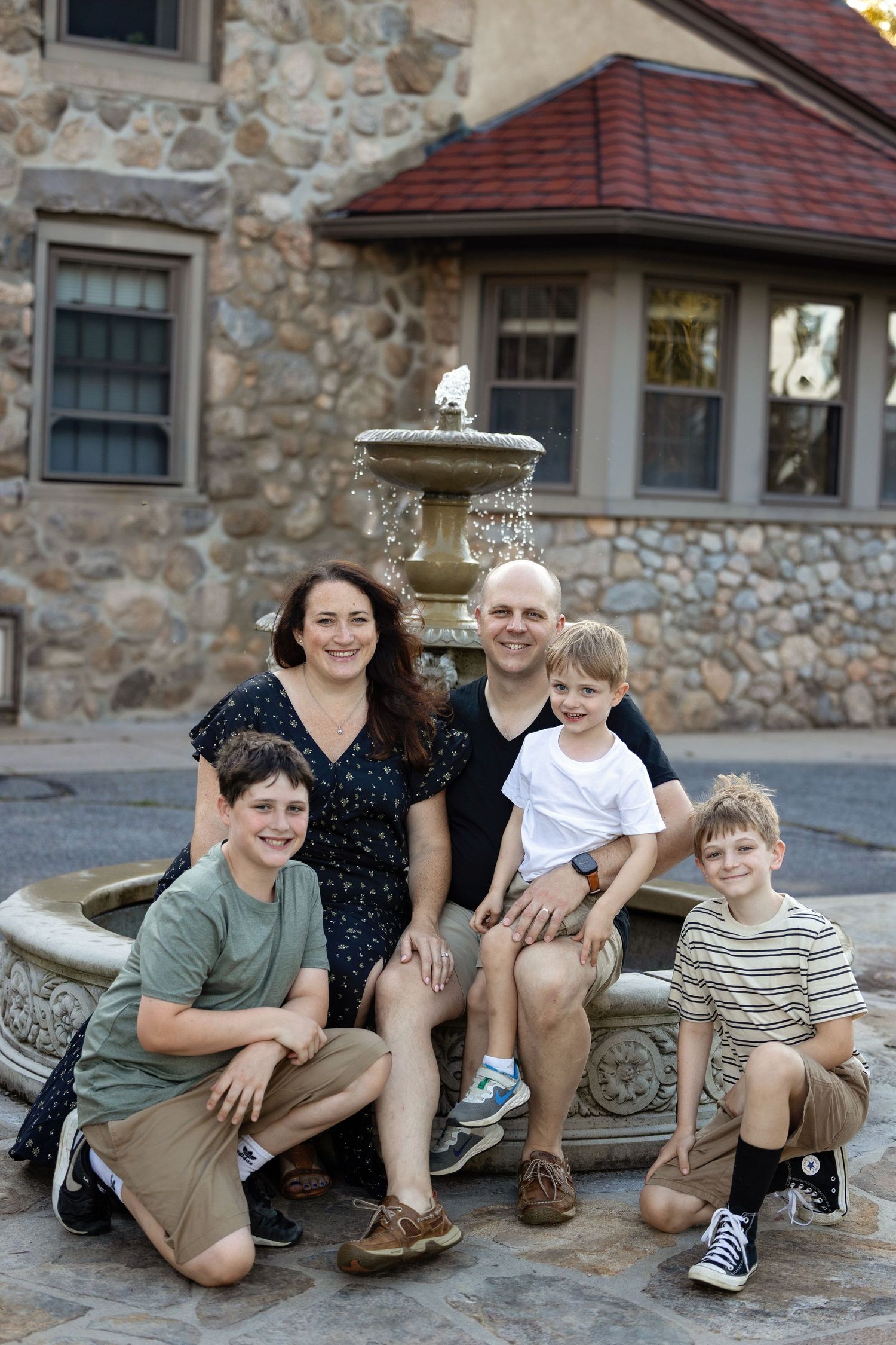 Family poses together on stone steps of rustic building with multiple similar poses in sequence.