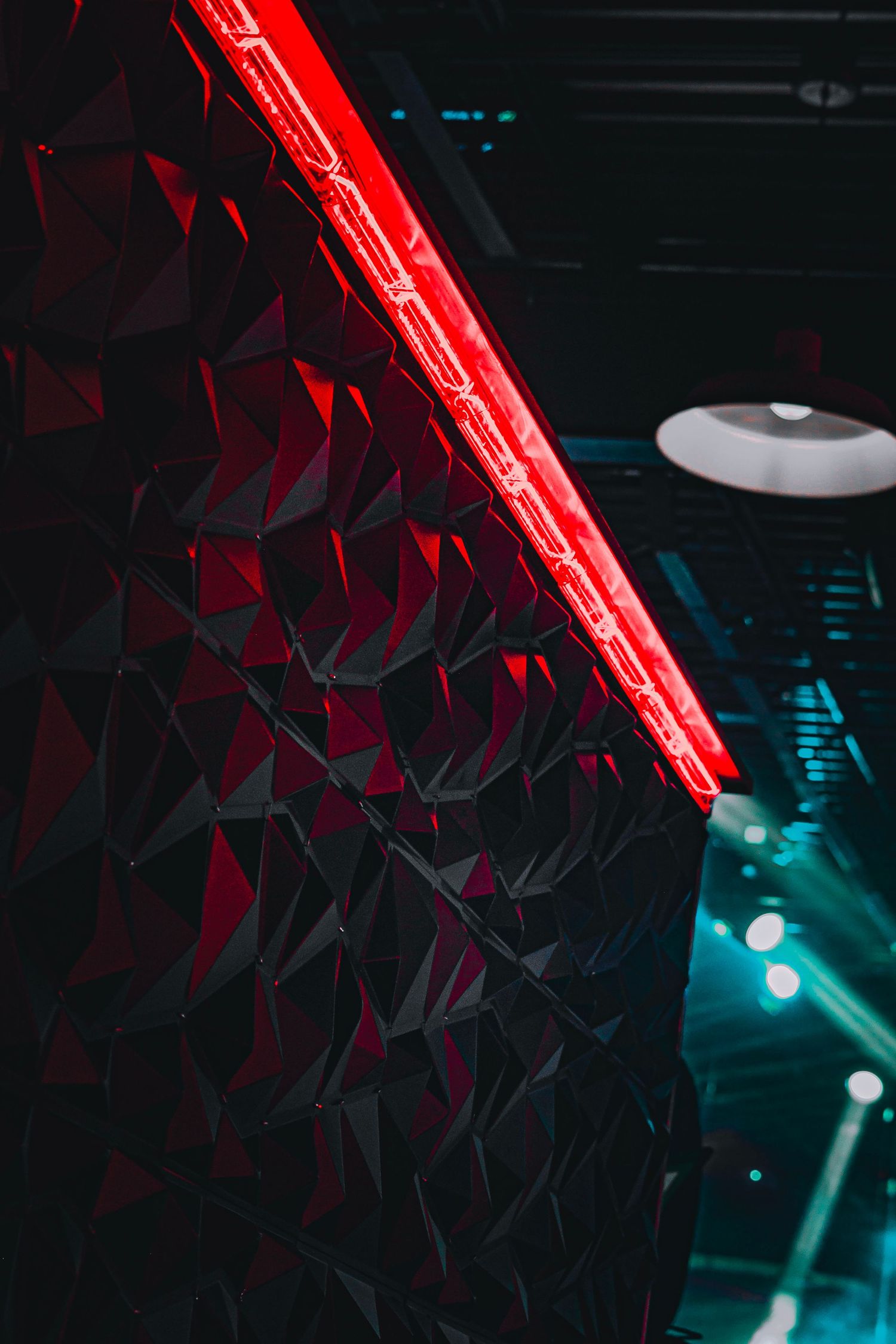 Abstract geometric pattern with red neon lighting against a dark background.