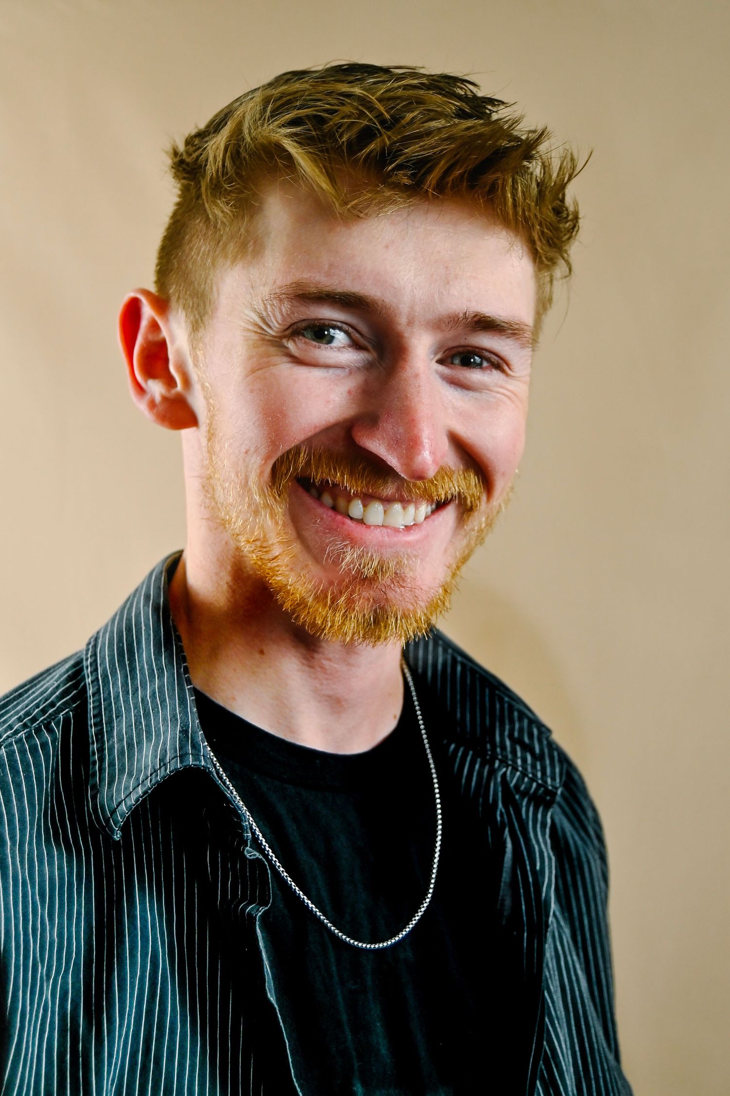 Four headshots showing expressions of joy and laughter against a neutral background.