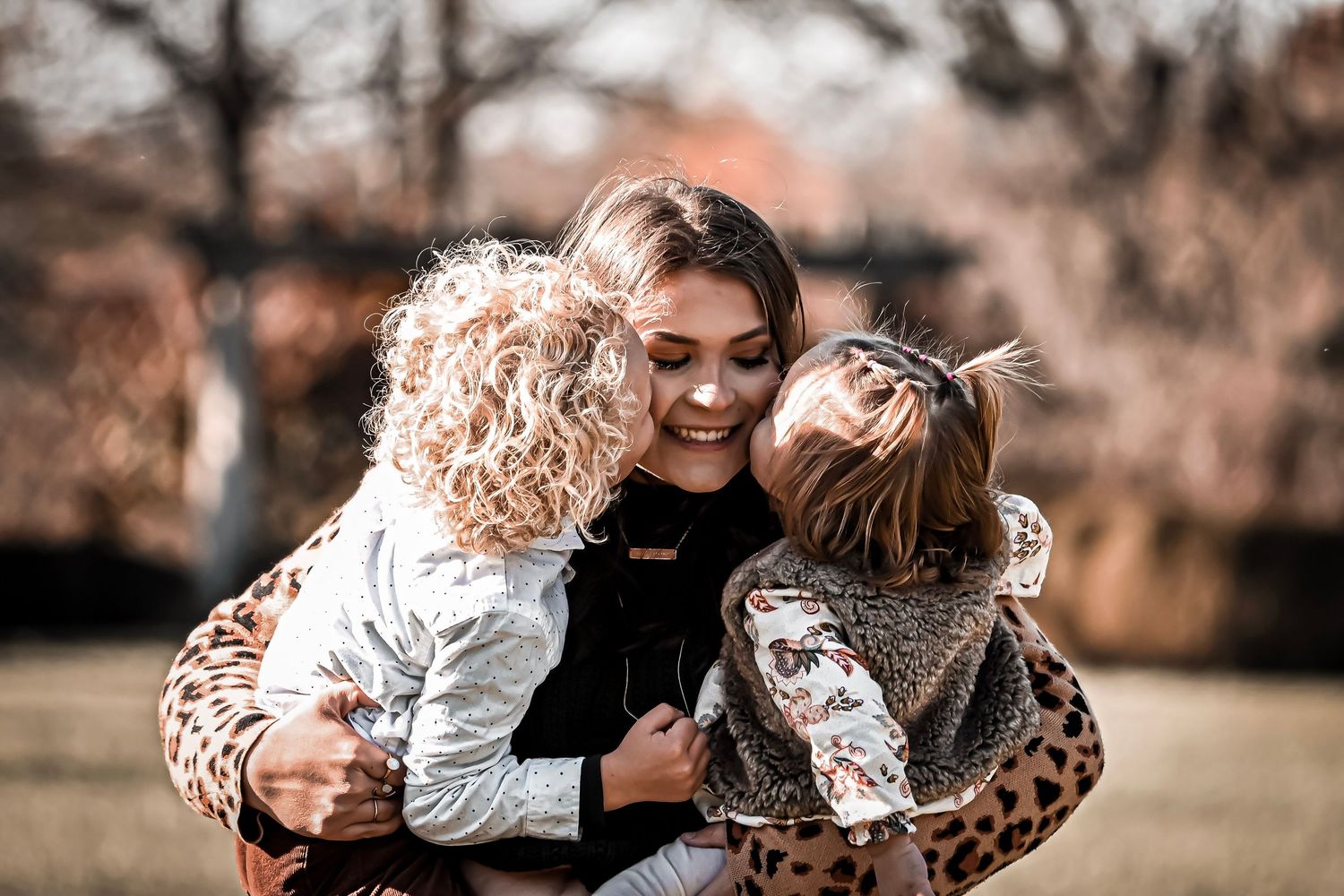 Joyful outdoor family moment captured in warm autumn lighting.