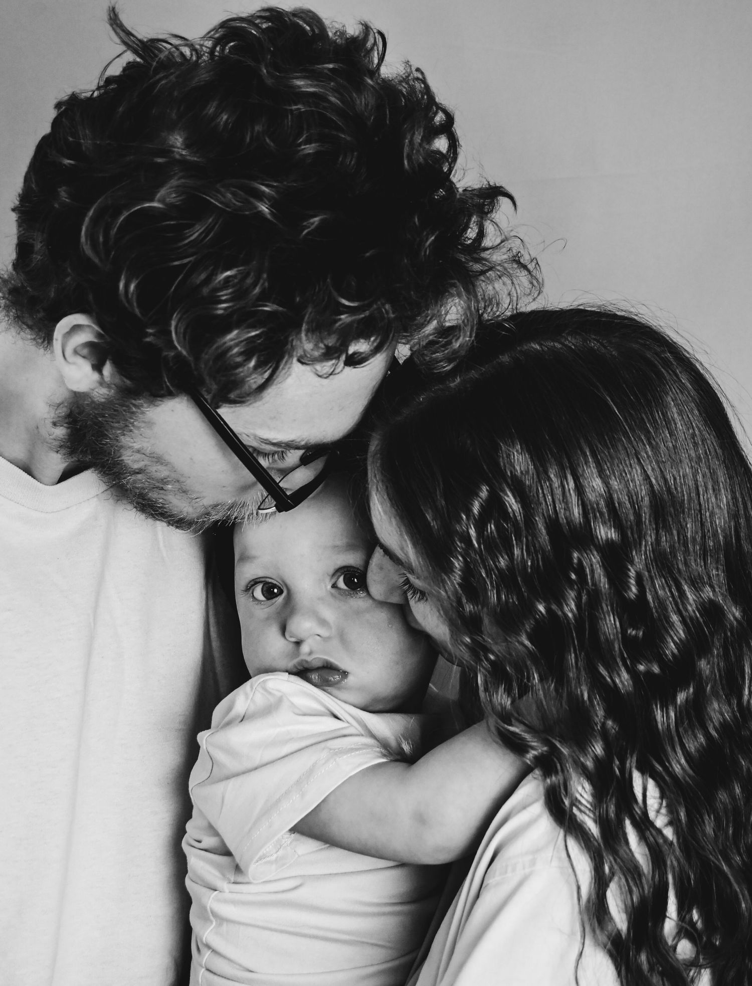 Black and white close-up photograph showing an intimate moment of affection and tenderness between two people.