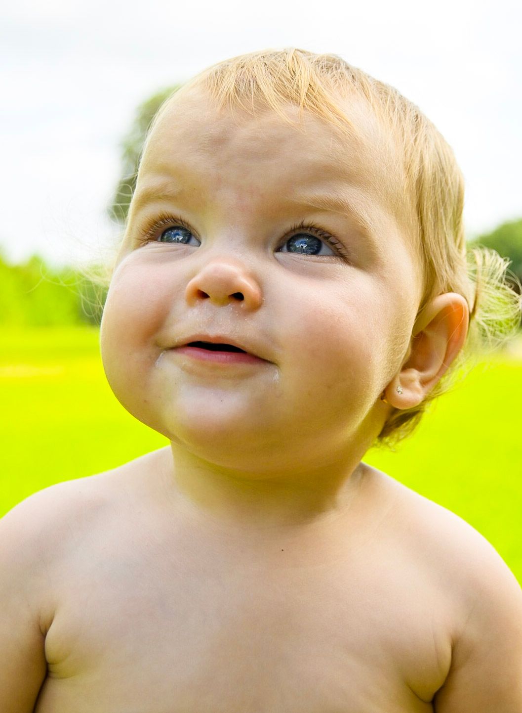 Close-up series of a smiling baby against bright green background.