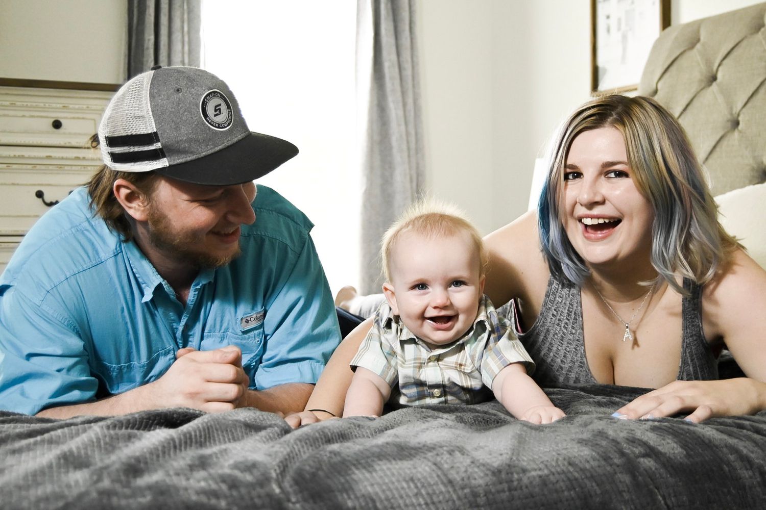 Family lying together on bed sharing playful moments in bedroom setting.