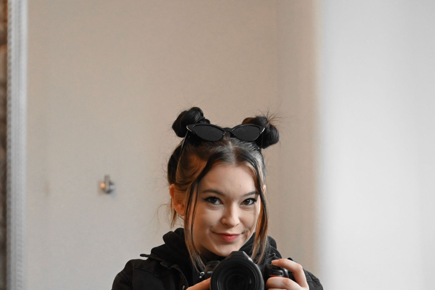 Portrait of a woman with space buns hairstyle wearing headphones.