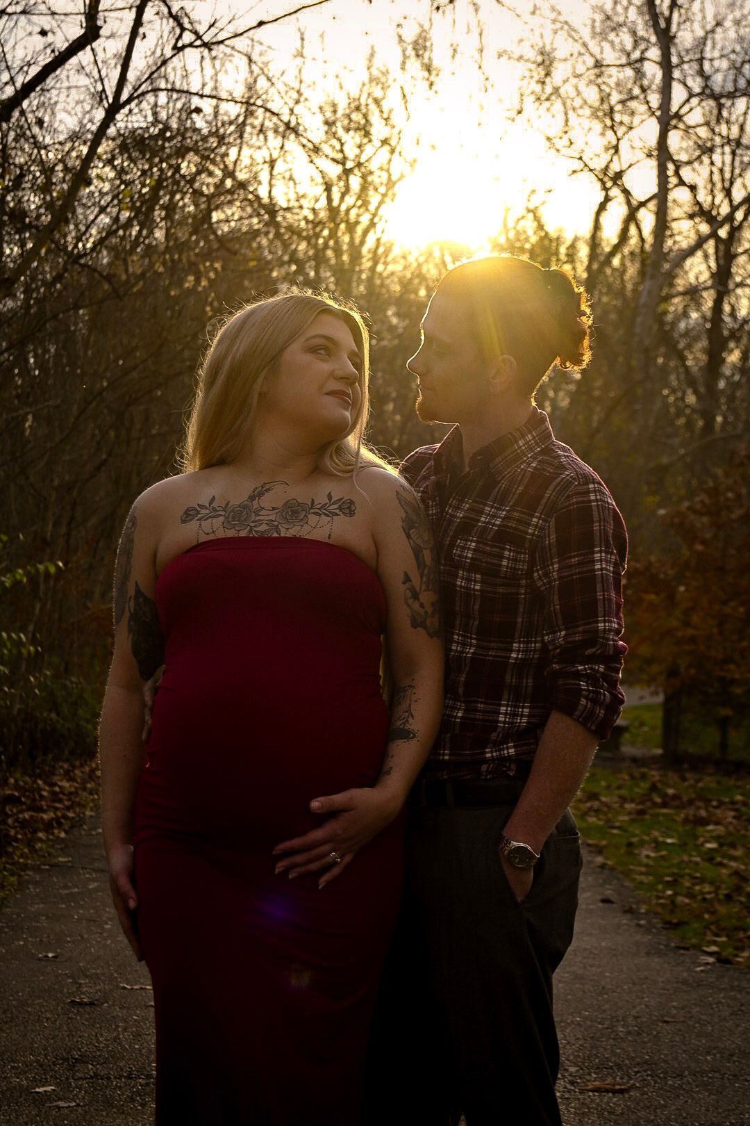 A couple poses together on a path during golden hour.