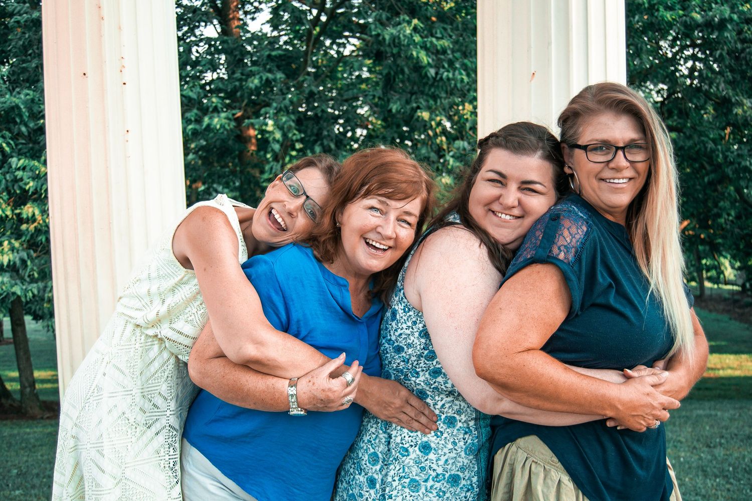 A series of candid photos showing joyful embraces and laughter between people in a park setting with white columns.