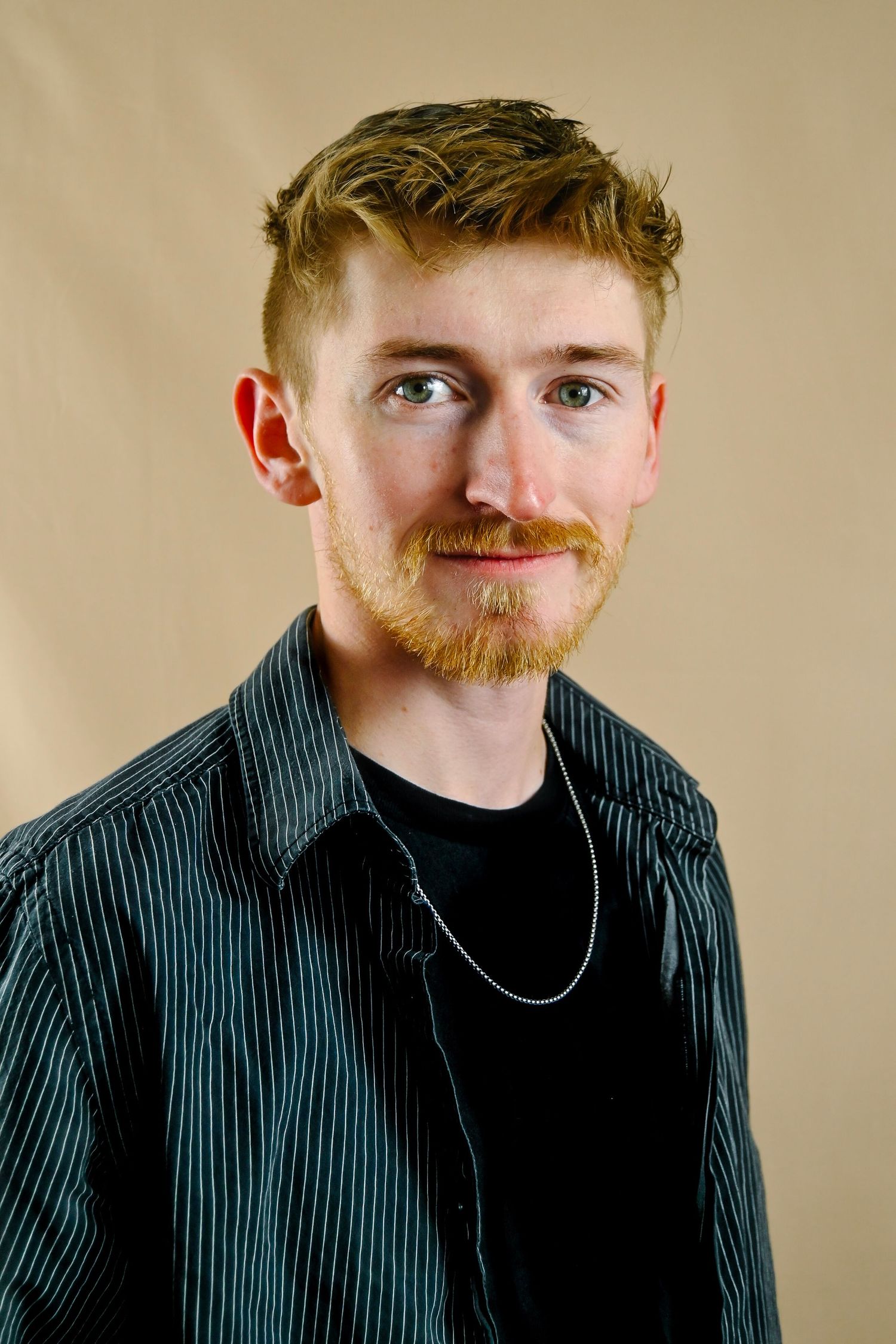 A series of four close-up portraits showing a person with ginger facial hair wearing black and striped clothing against beige wall.