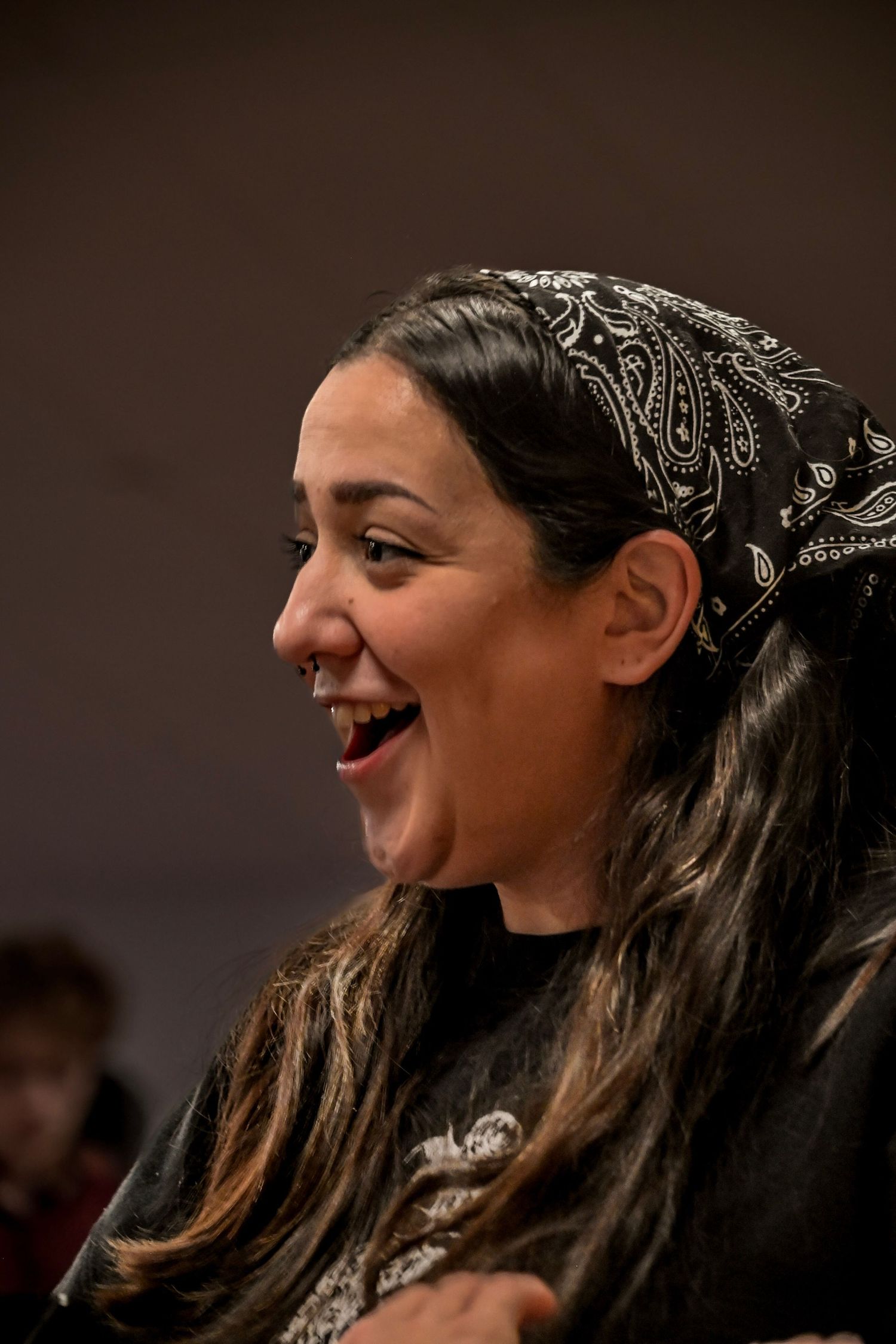 Person wearing bandana smiling and laughing in sequence of candid shots.