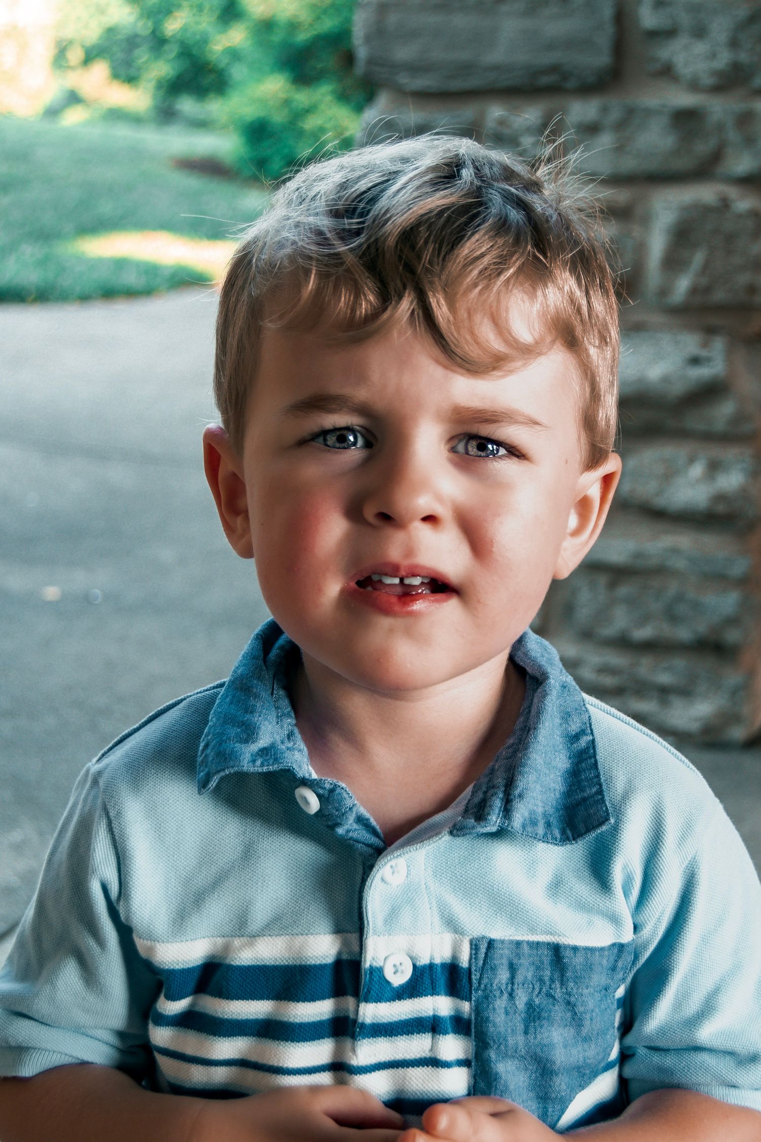 Portrait sequence of young child in blue collared shirt.