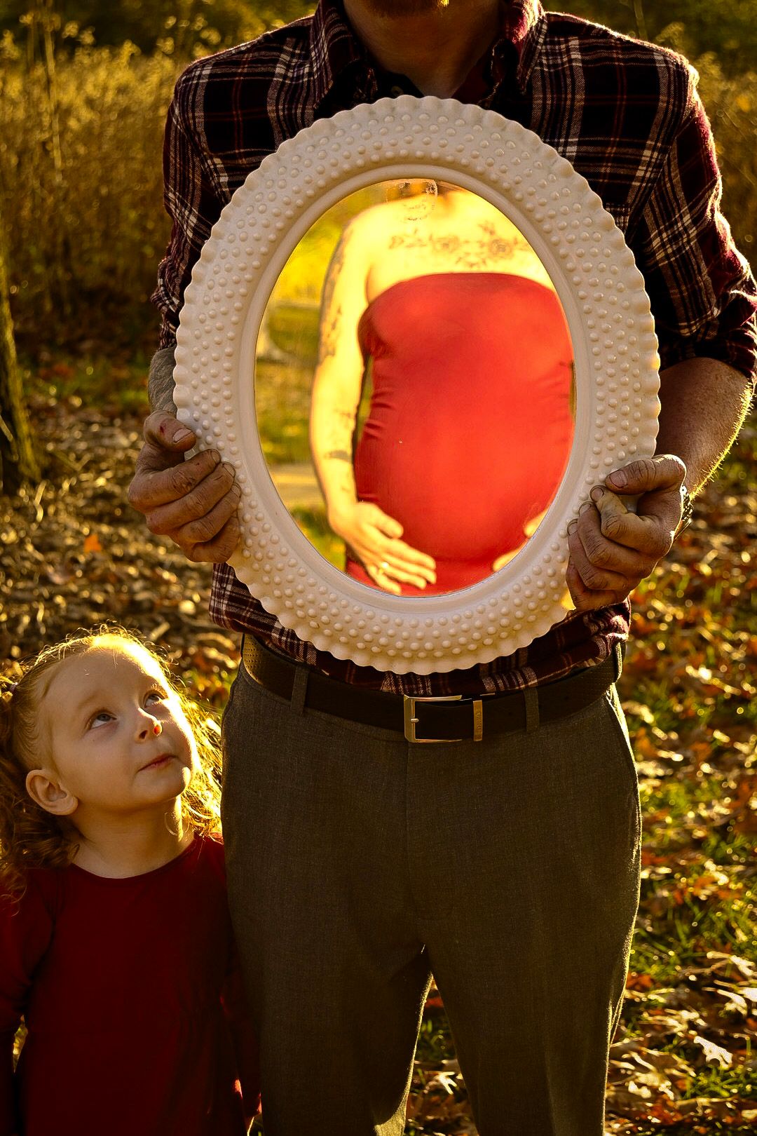 A creative maternity photo using a white frame to highlight the baby bump.