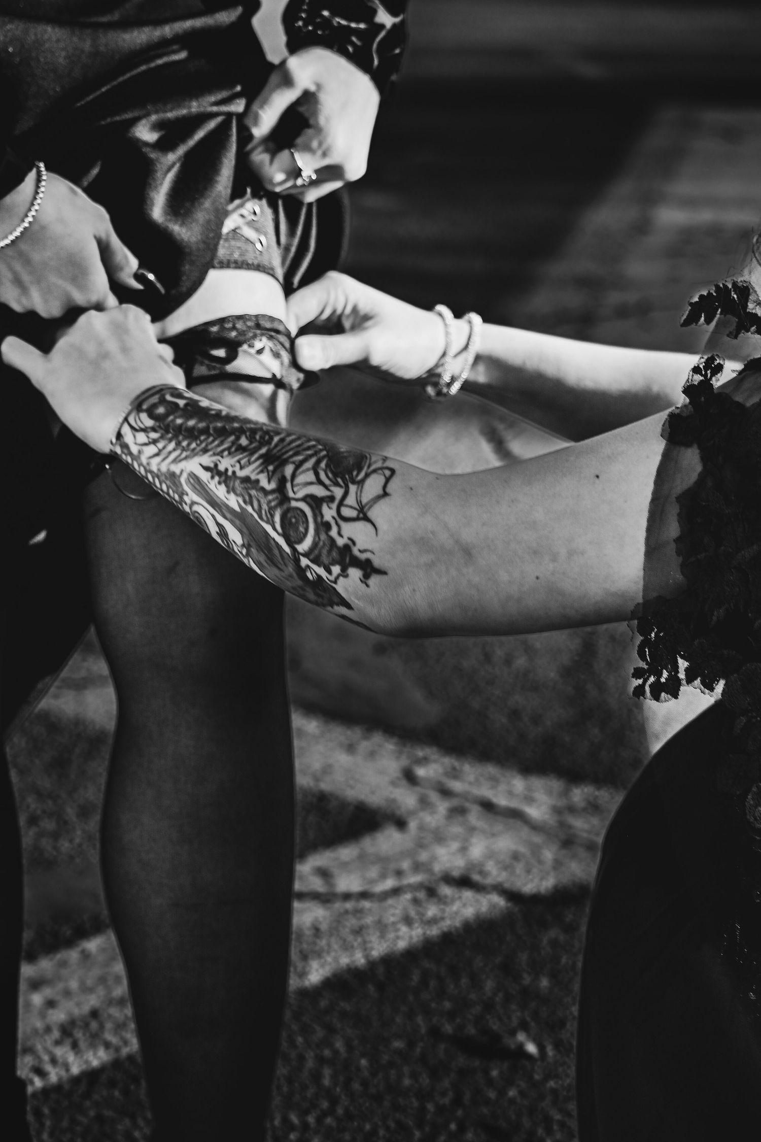 Black and white image showing detailed leg tattoo artwork being photographed on someone wearing dark stockings.