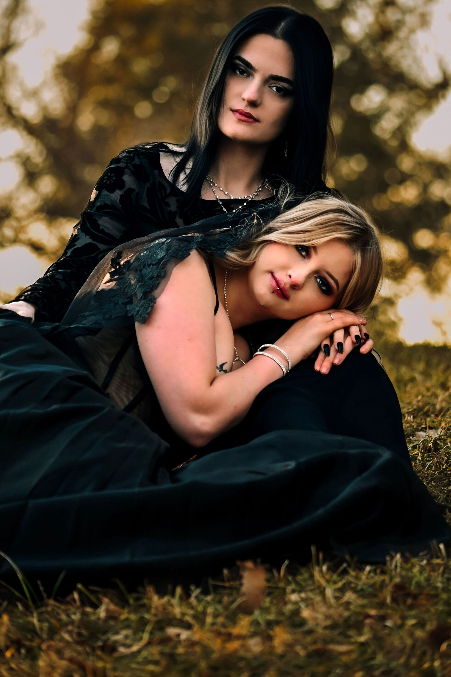 A moody outdoor portrait series showing two people in dark clothing lying on grass during golden hour.
