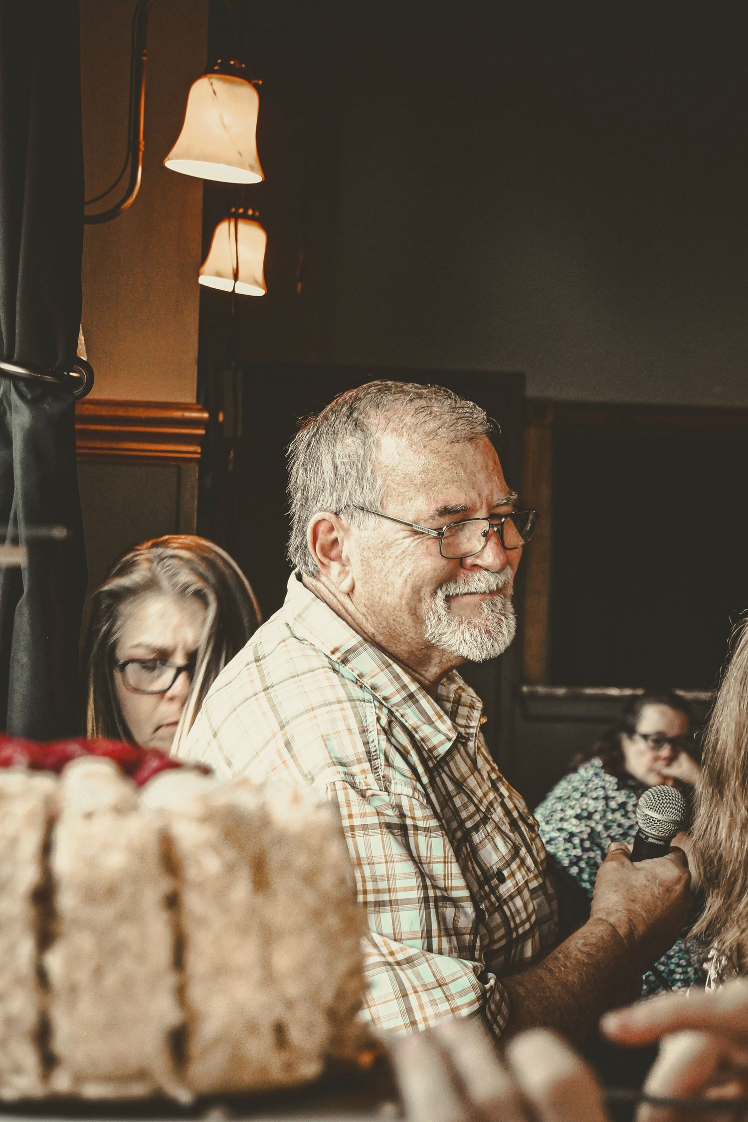 Candid shot of people enjoying conversation under warm lighting at a social gathering.