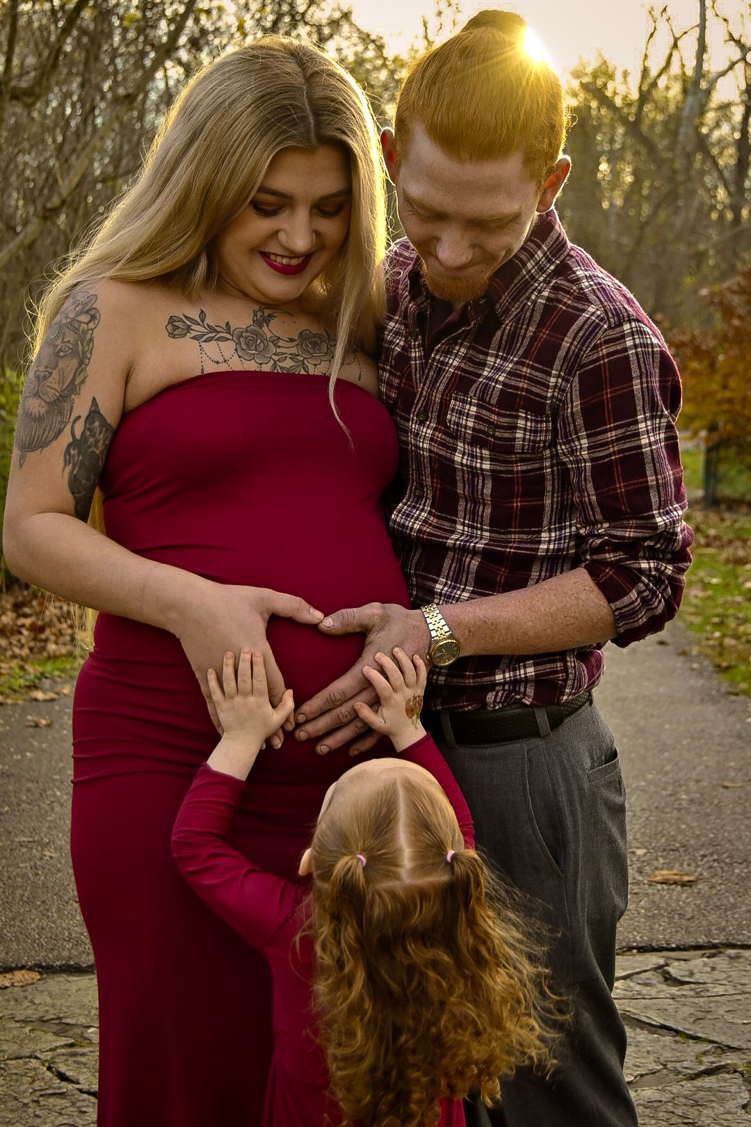 A couple in red and plaid share an intimate moment at sunset.