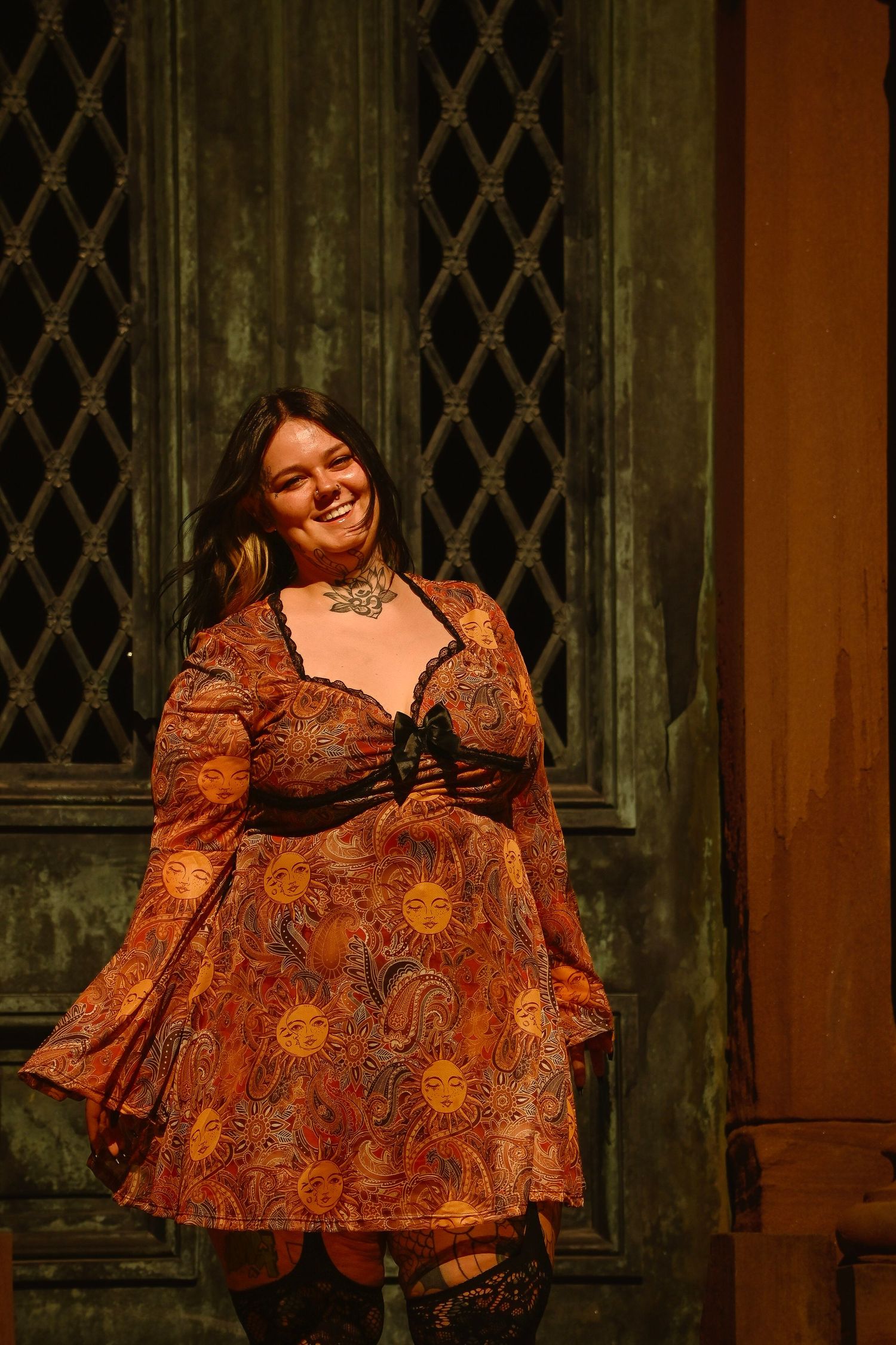 Four sequential photos show someone wearing a flowing rust-colored floral dress posing against a gothic window backdrop.