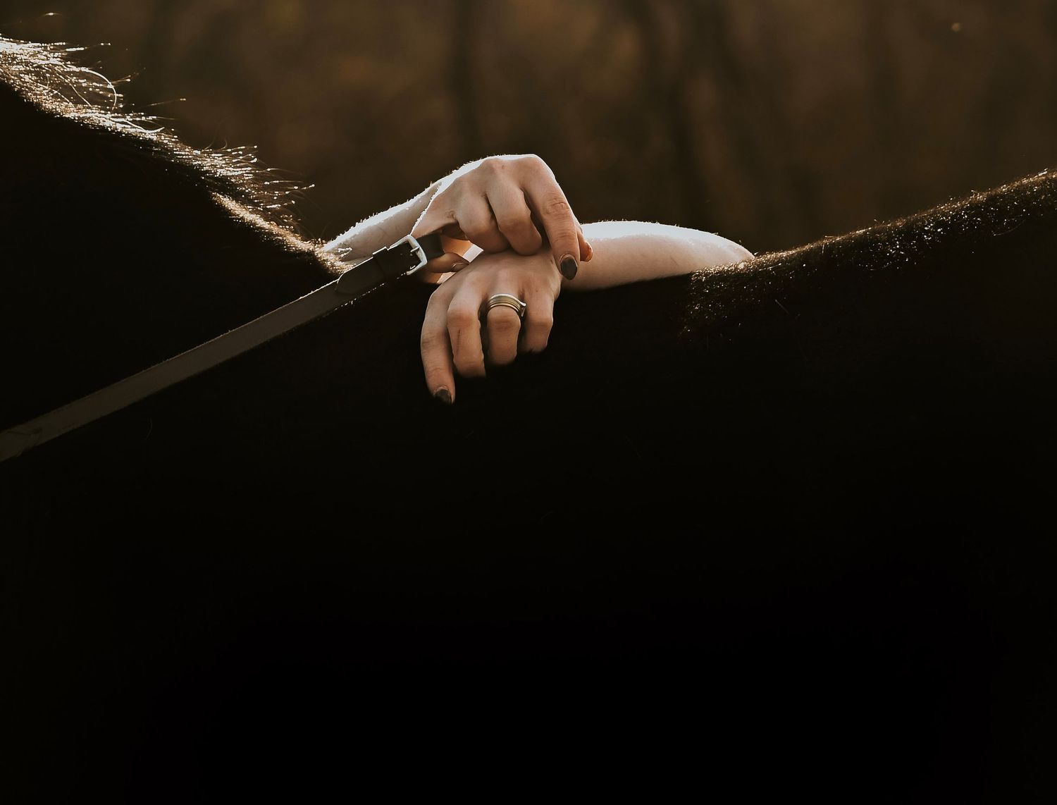 A hand gripping a tightrope with taped fingers against a dark bokeh background.