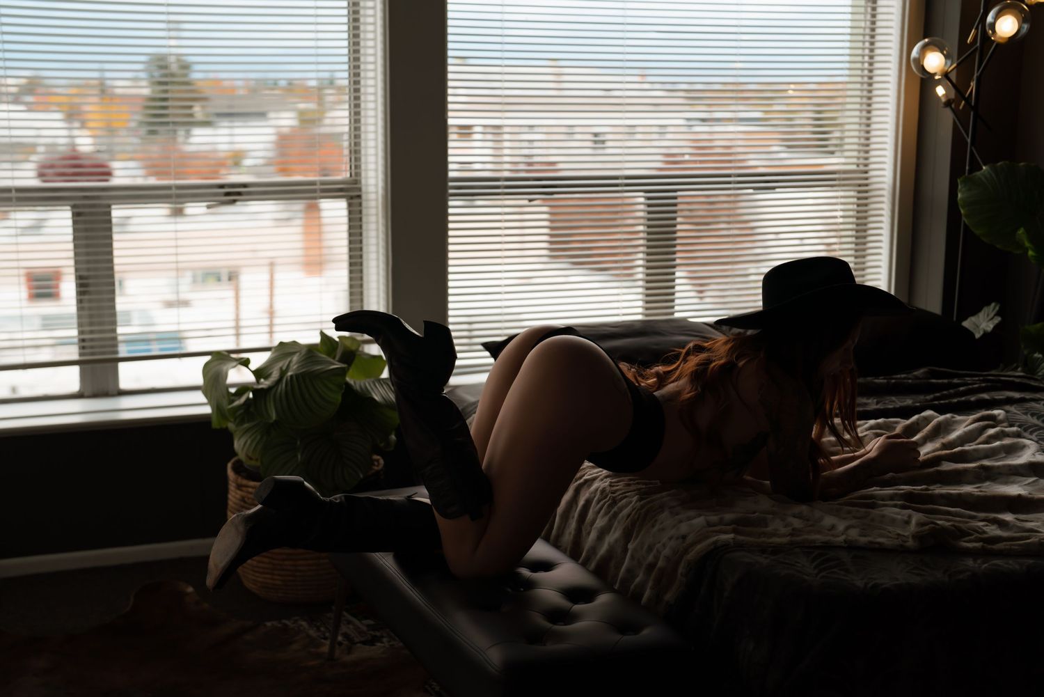 Bright window light creates silhouettes in minimalist indoor portrait setting.
