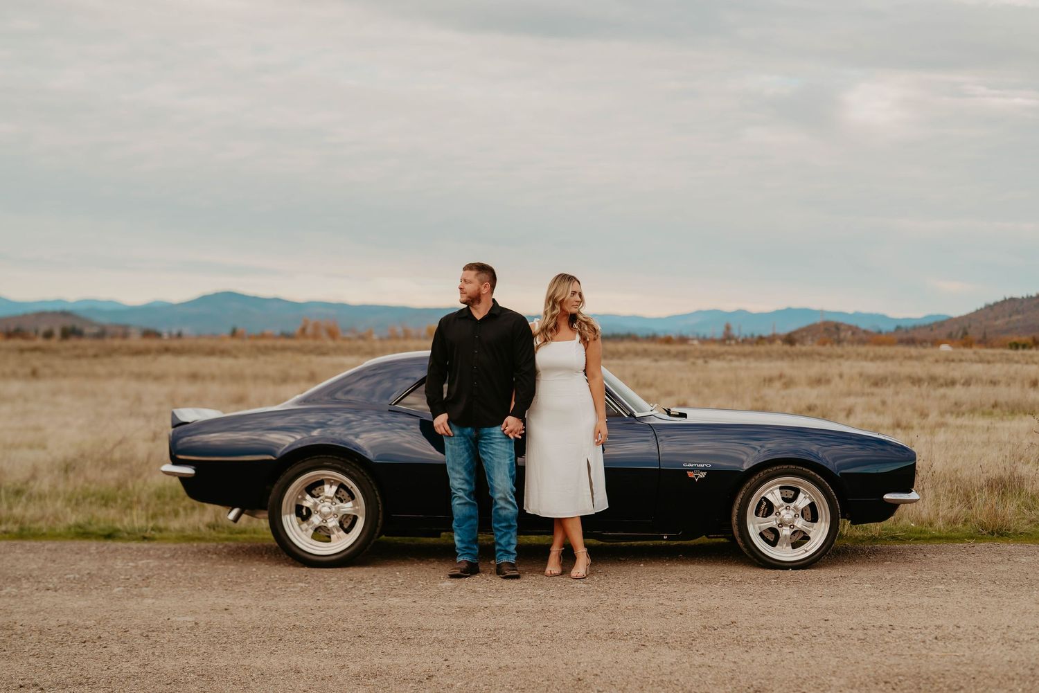 Classic car photoshoot in desert landscape with mountains in background.